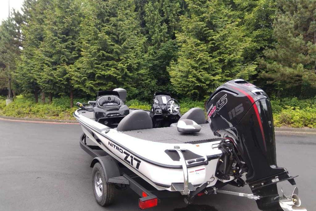 2026 Nitro Z17 boat with powerful outboard motor, parked near lush green trees.