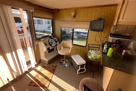 Interior of a 1995 Myacht 40X13 houseboat with helm, seating, and kitchenette.