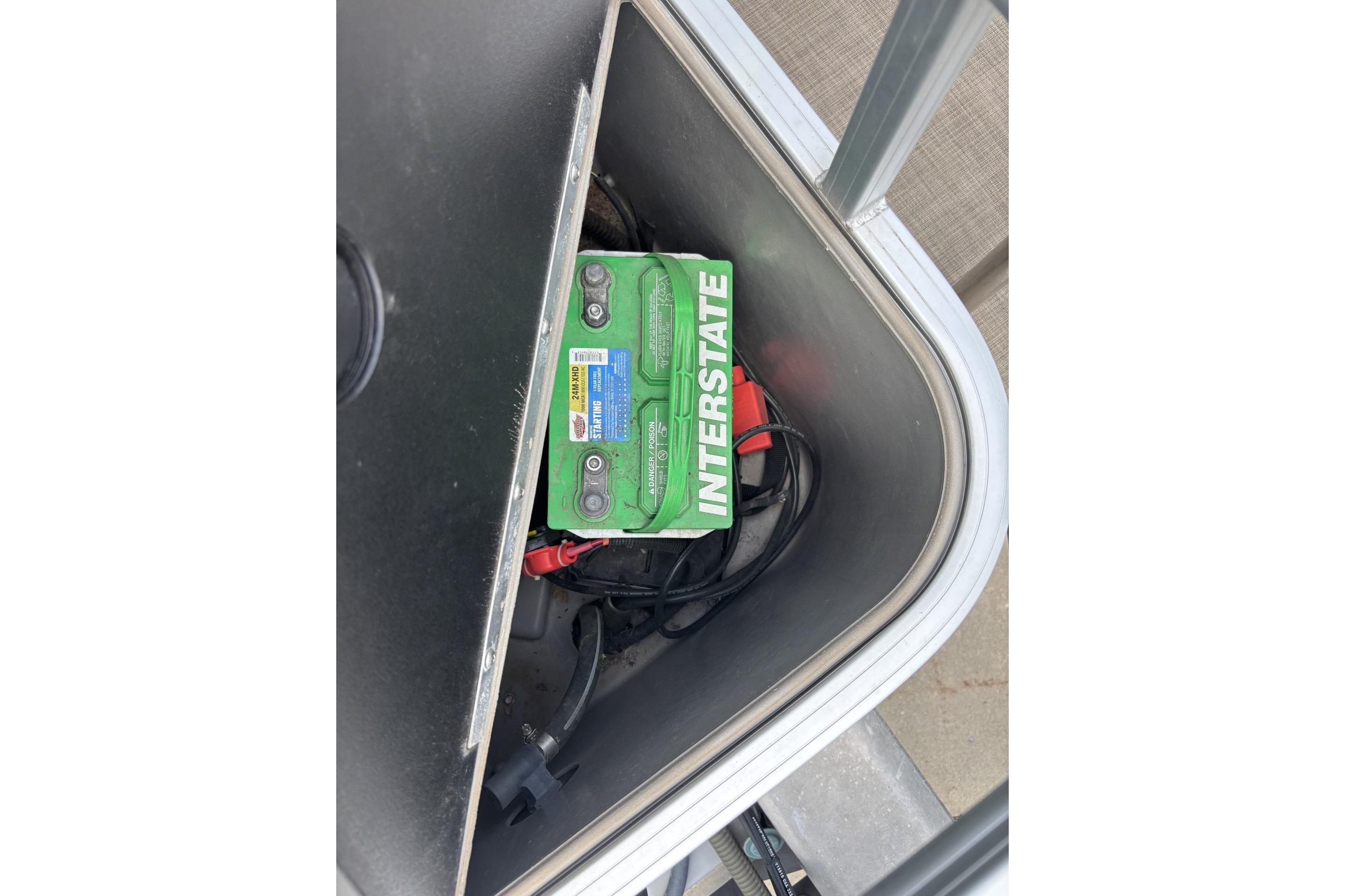 Battery compartment of 2023 Sun Tracker SportFish 20 DLX with Interstate battery visible.