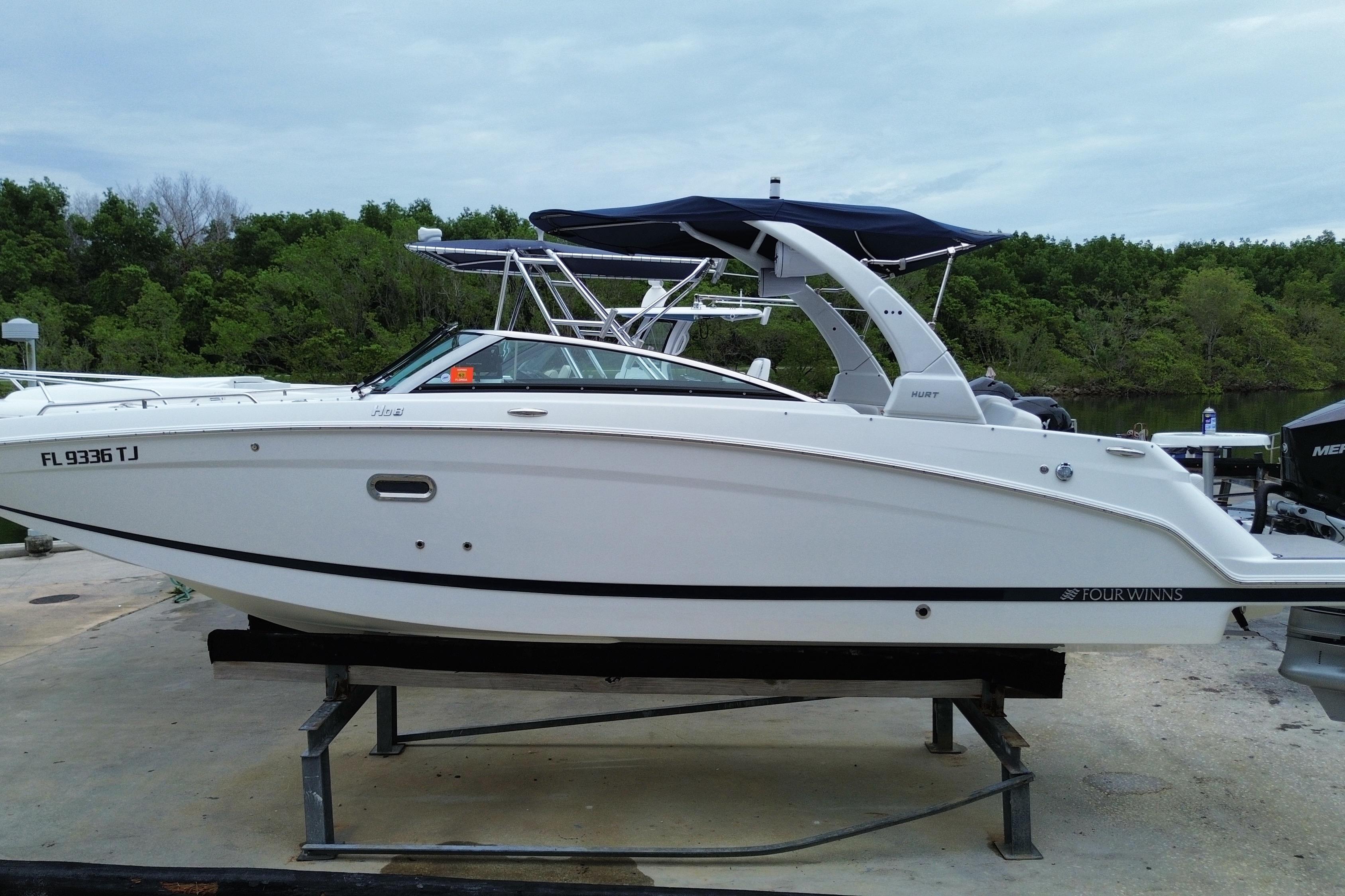2022 Four Winns HD8 OB boat on a stand, surrounded by greenery.
