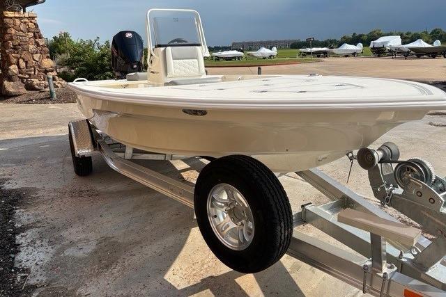 2026 Mako 18 Pro Skiff on trailer, parked outdoors, showcasing sleek design and sturdy build.