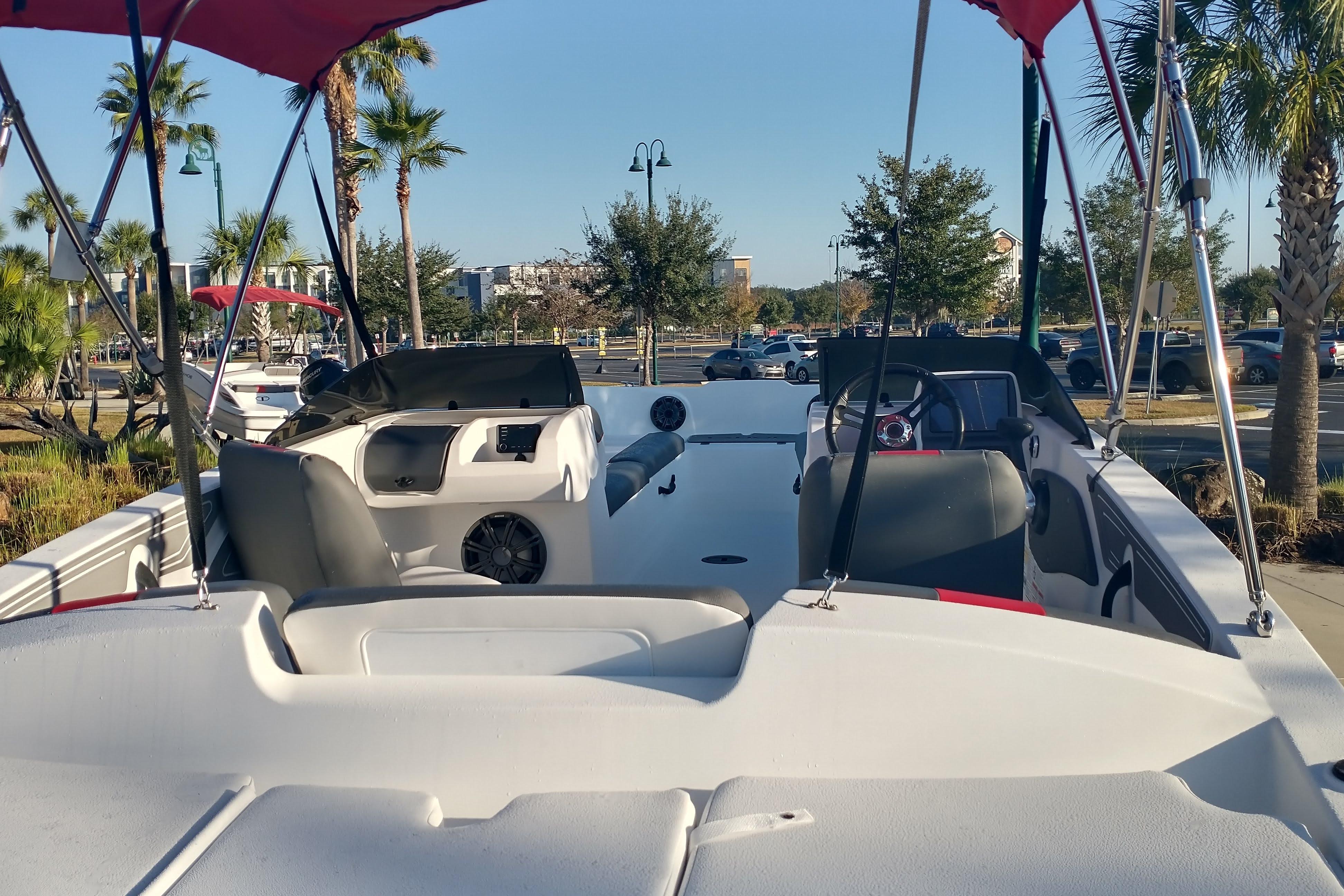 2026 Tahoe T21 boat interior with canopy, parked outdoors under clear sky.