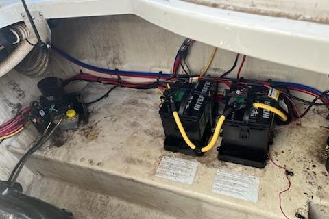 Battery compartment of a 2012 Bayliner 285 Cruiser with wiring and components visible.