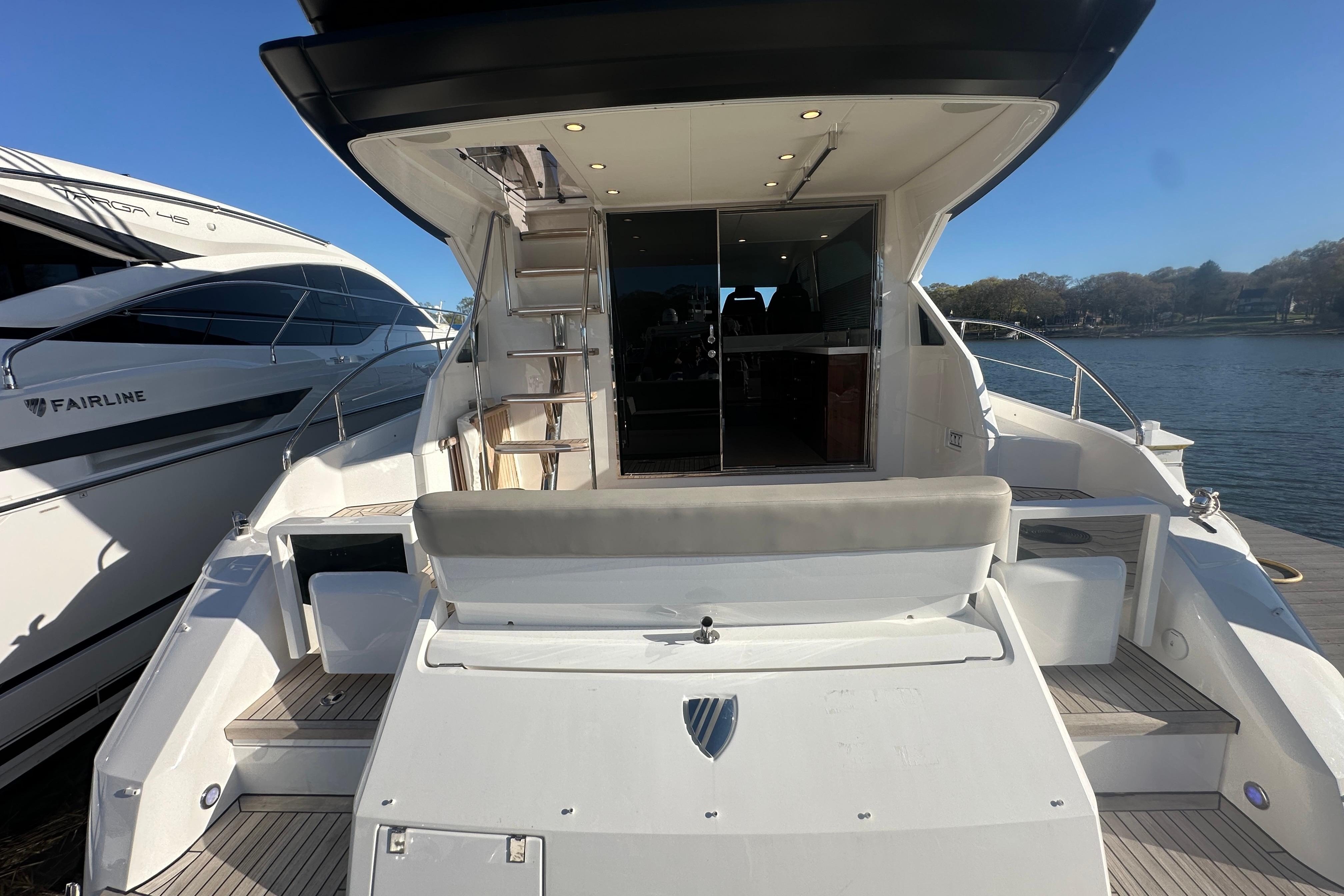 2024 Fairline Squadron 50 yacht with spacious deck and modern design, docked by the water.