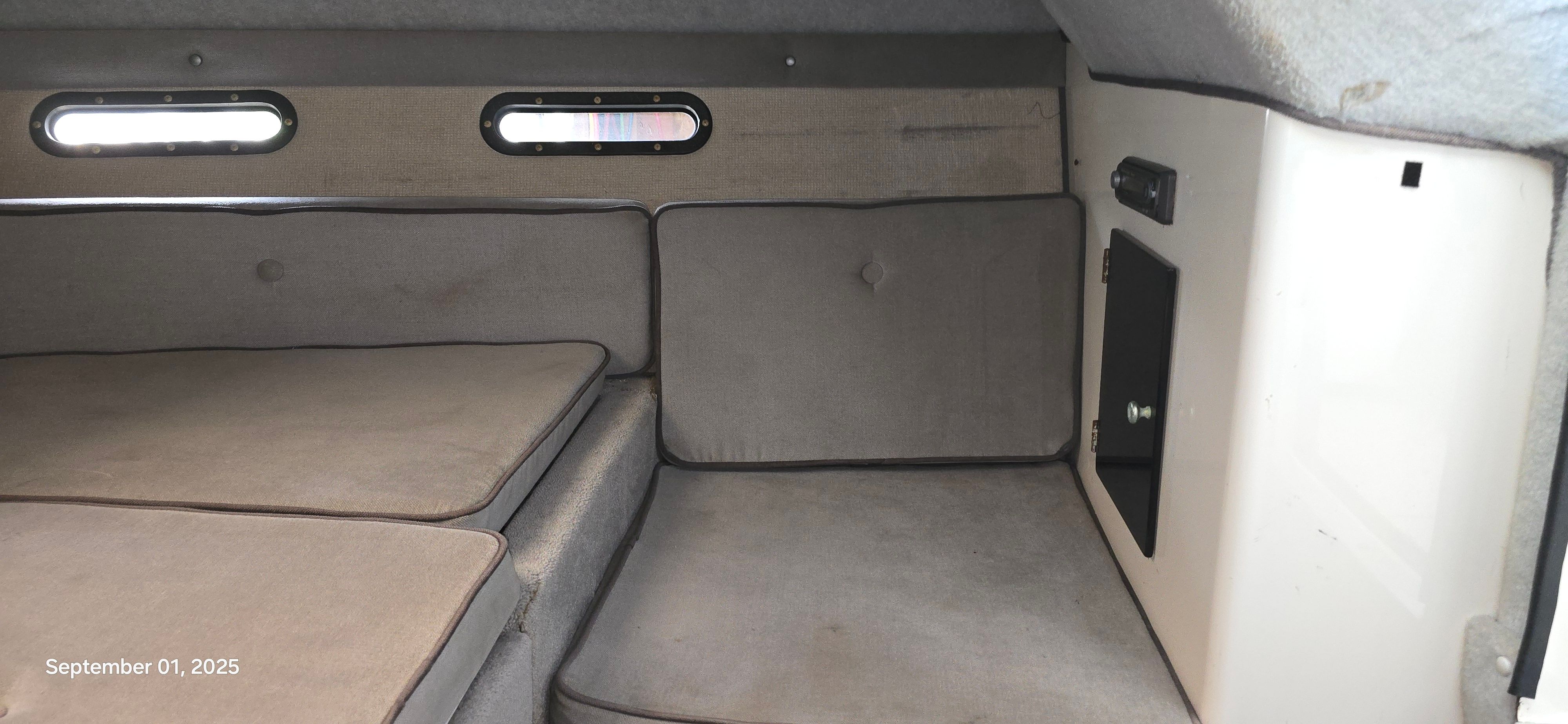 Interior of a 1989 Baja FORCE 235 with gray cushions and small windows.