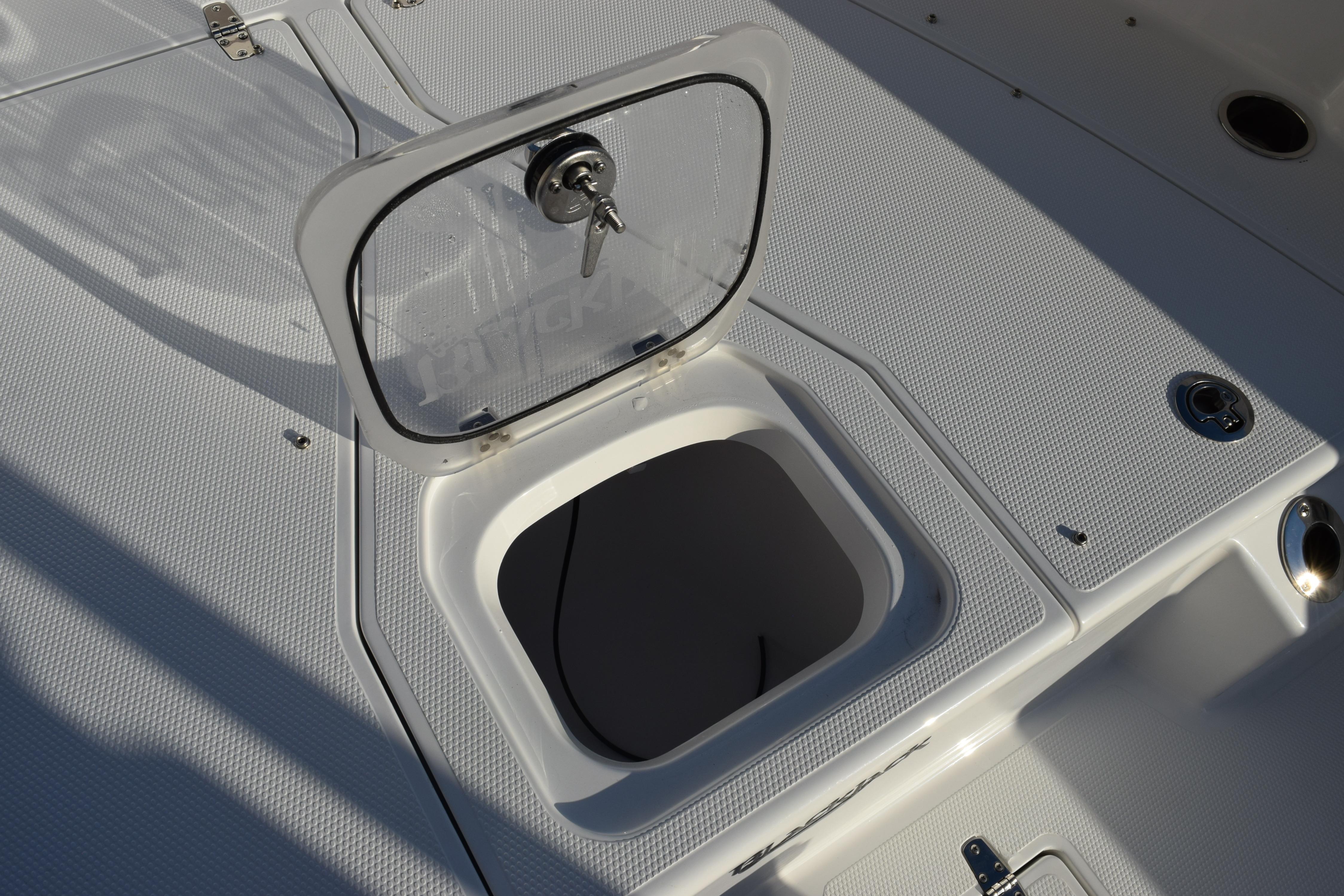 Open hatch on 2026 BlackJack 256 Coastal boat deck, showcasing storage compartment.