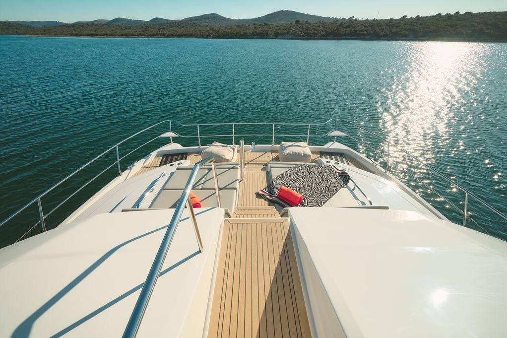 Luxurious 2024 Aquila 54 Yacht deck with scenic ocean view and sunlit surroundings.