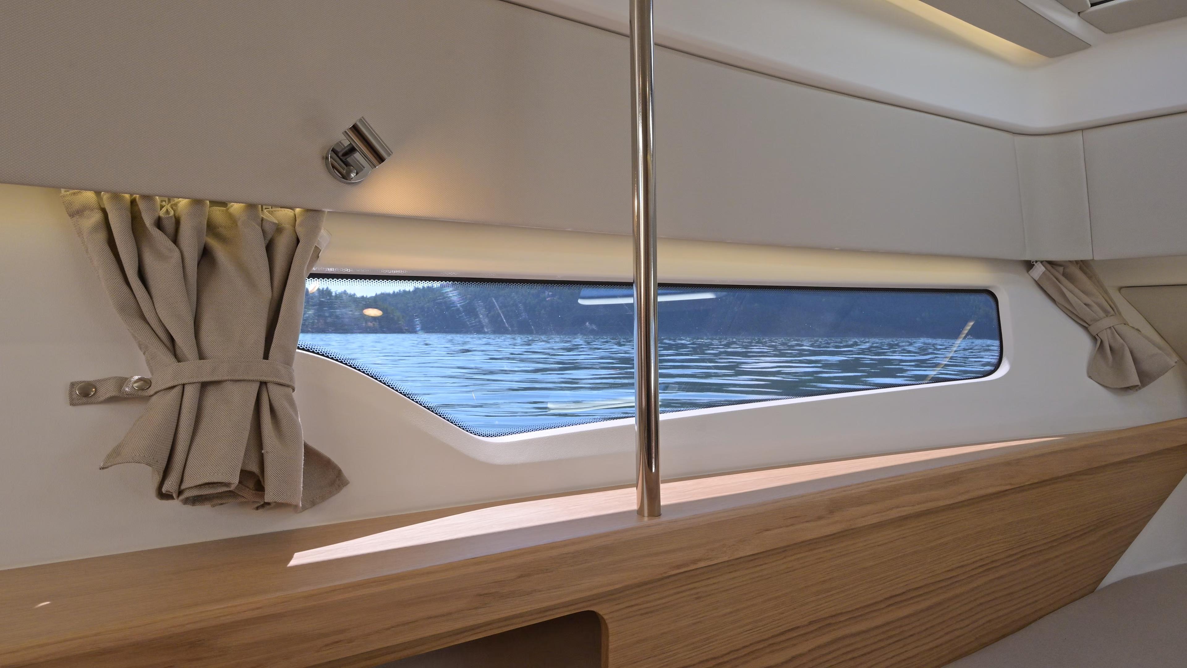 Interior view of 2025 Nimbus W11 boat with window overlooking water.