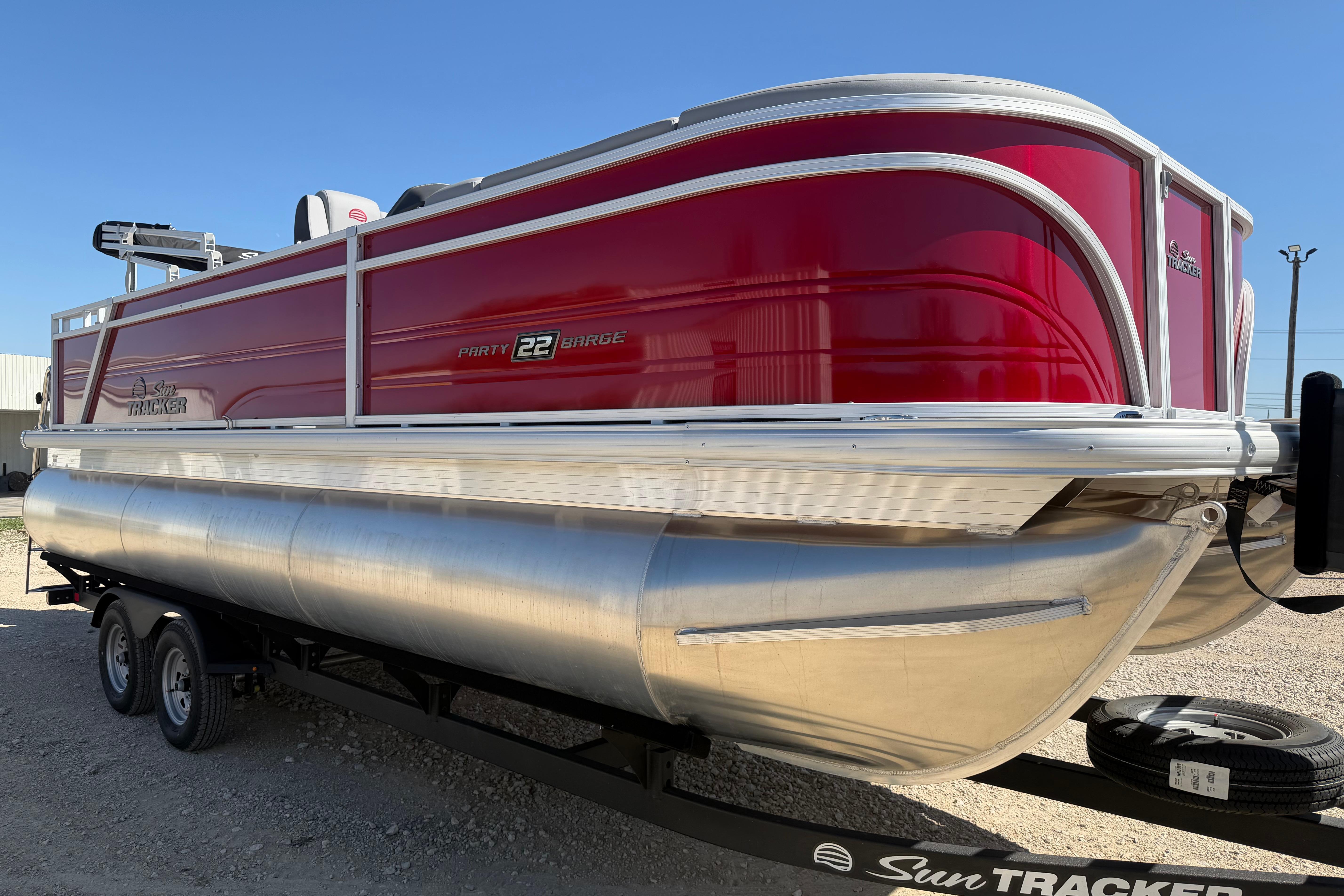 2026 Sun Tracker Party Barge 22 RF XP3 pontoon boat with red exterior on trailer.