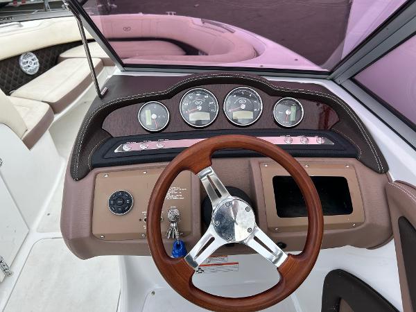 2010 Cobalt 262 boat dashboard with wood steering wheel and instrument panel.