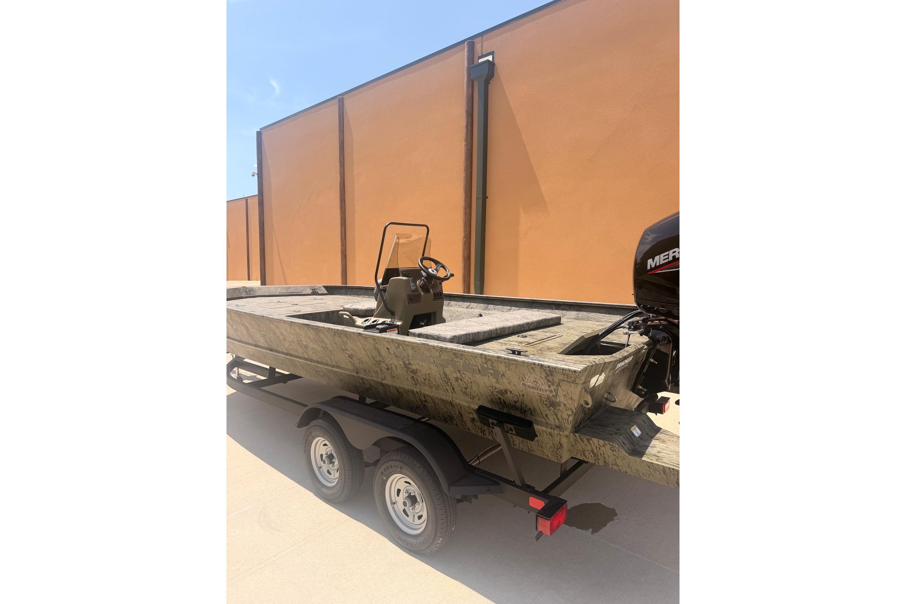 2026 Tracker Grizzly 2072 CC boat on trailer, parked outdoors.