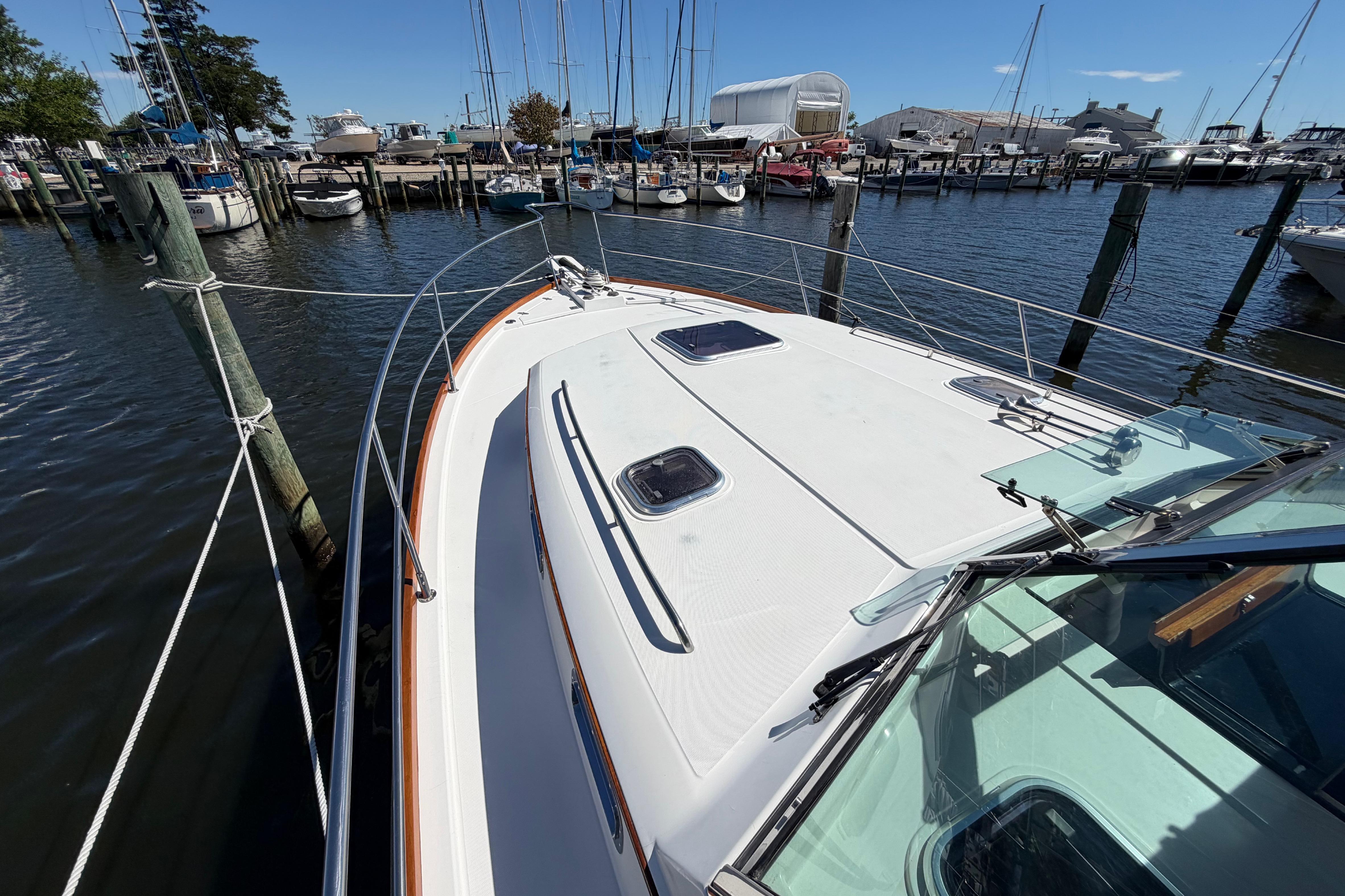 2000 Sabreline 36 Express yacht docked at a marina with sailboats in the background.
