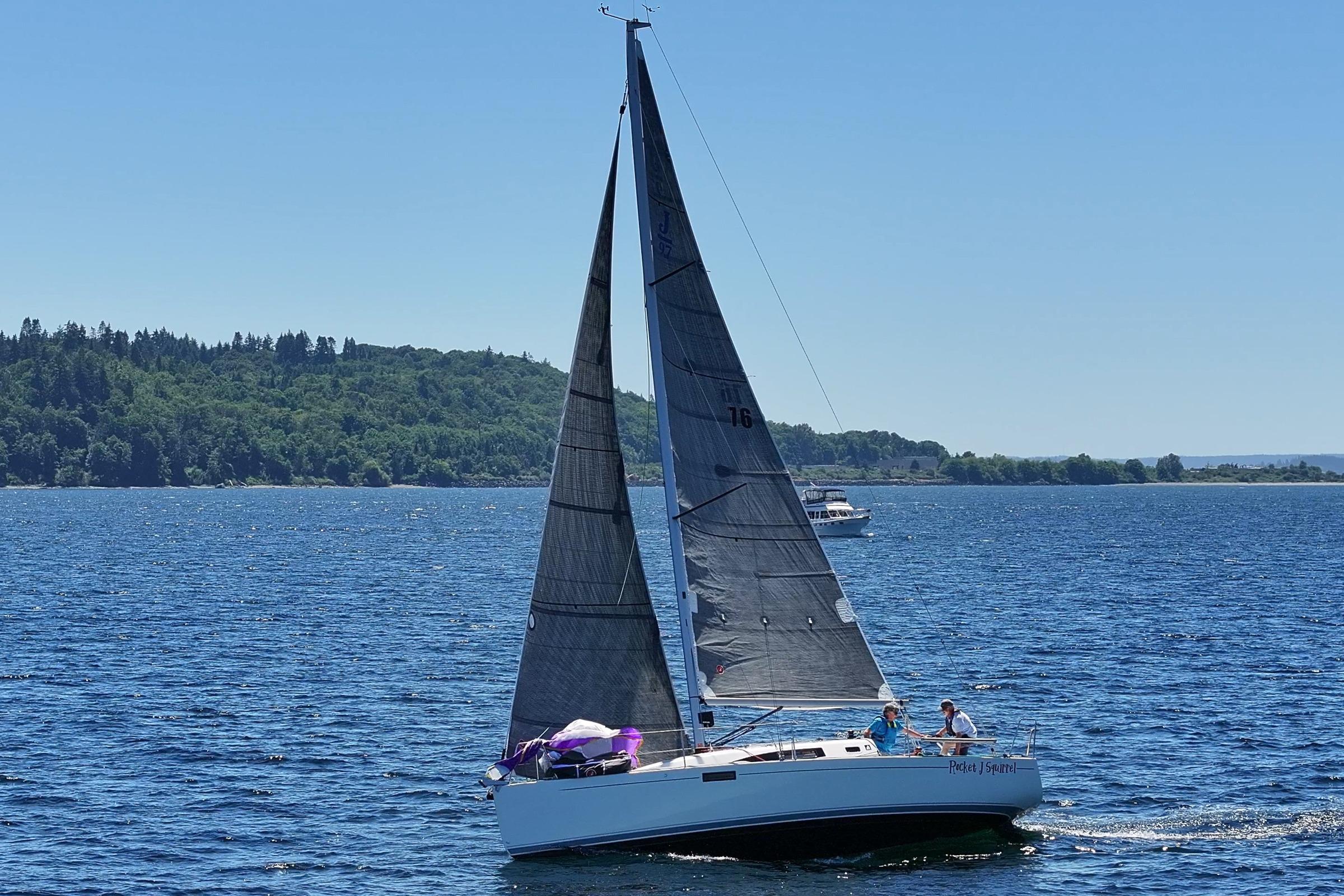 2018 J Boats J/97E sailing on a sunny day with lush green shoreline.