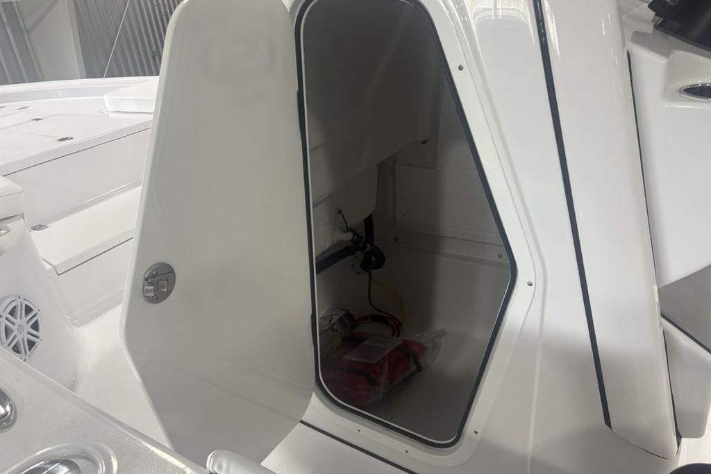 Open storage compartment on 2026 Sportsman Masters 227 boat, showcasing interior space.