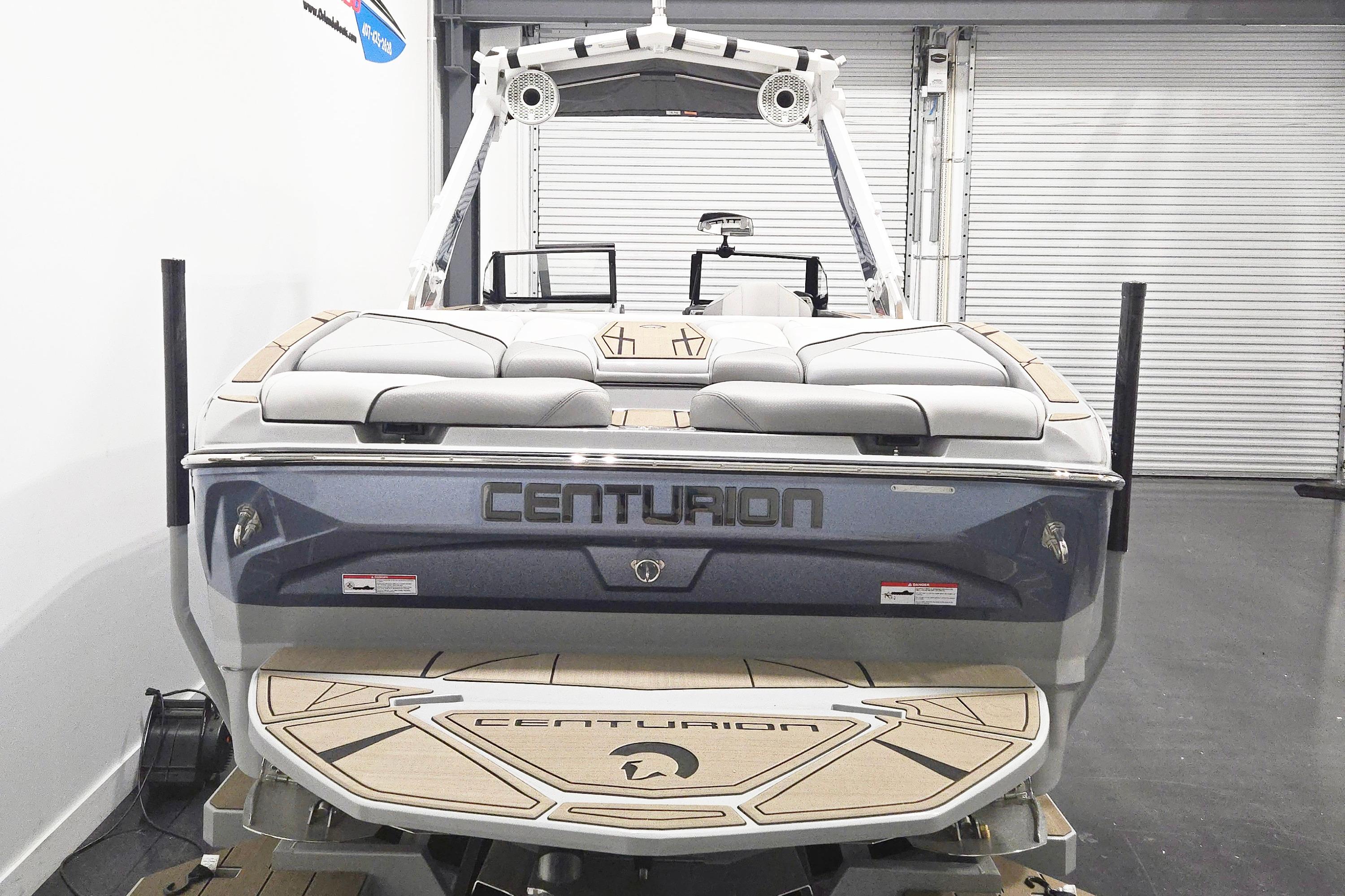 2026 Centurion Nv243 boat, rear view in showroom, featuring sleek design and comfortable seating.