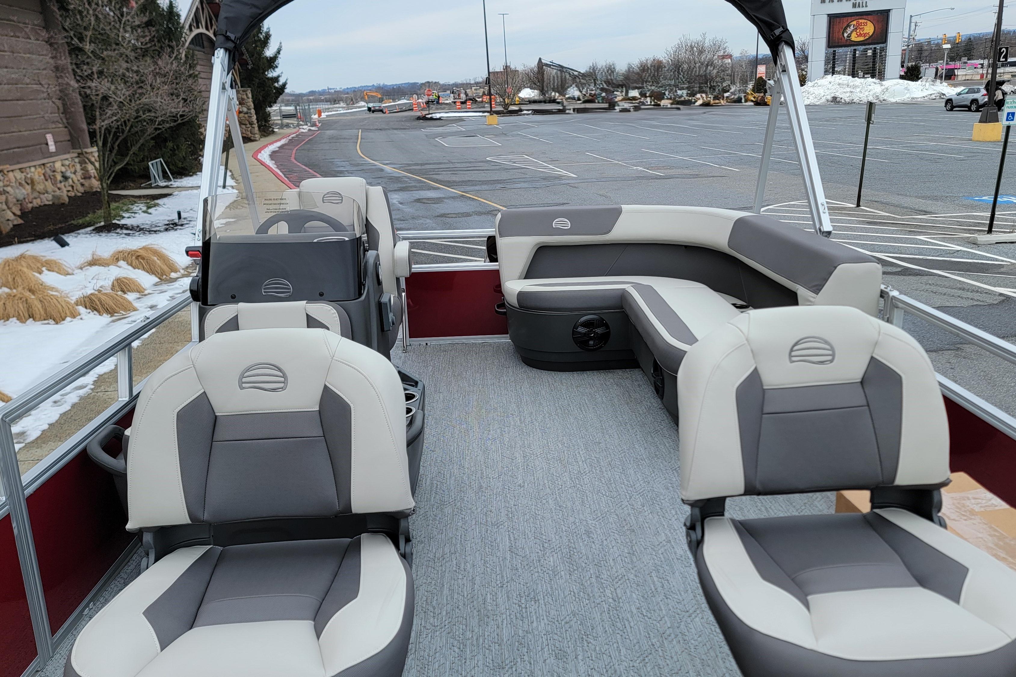 2026 Sun Tracker Bass Buggy 16 XL Select pontoon boat interior with seating in a snowy parking lot.