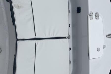 2025 Stingray 173CC boat interior with white cushioned seating and storage compartments.
