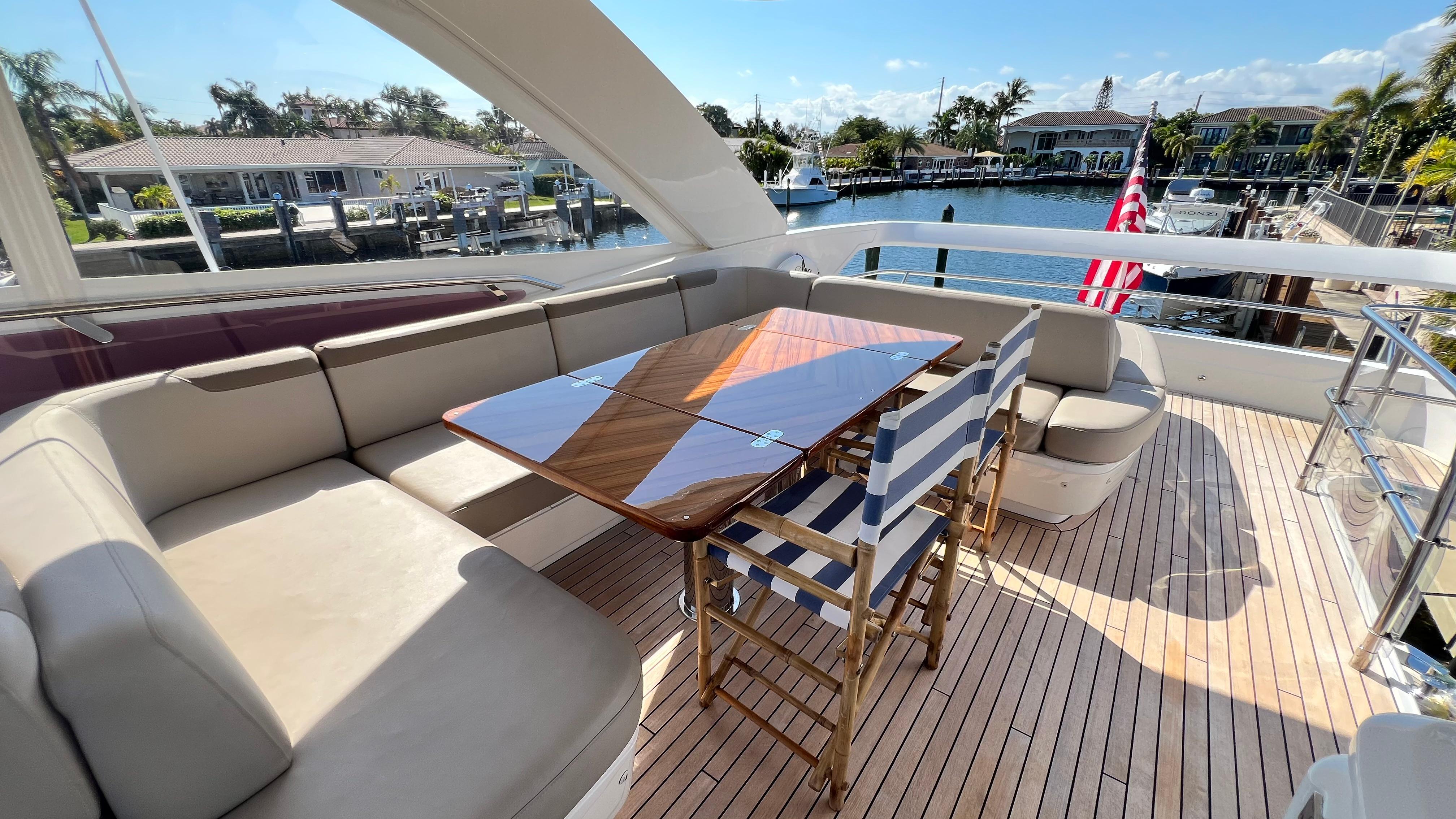 Luxurious 2019 Princess F62 yacht deck with seating, table, and waterfront view.