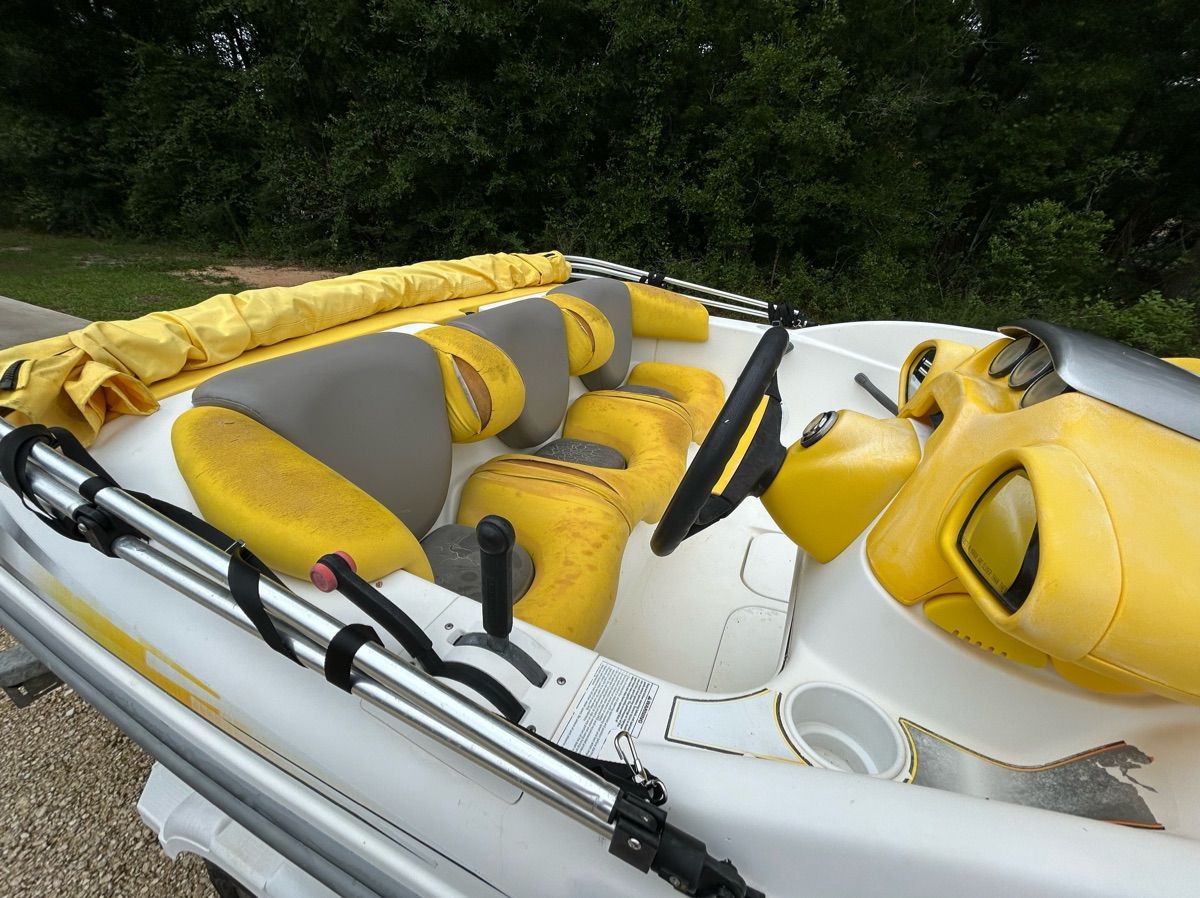 A yellow and white 2004 Sea-Doo Sportster LE DI boat with cushioned seats.
