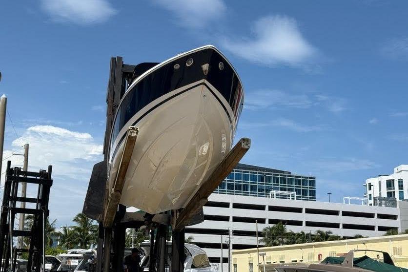 2014 Regal 2500 Bowrider boat lifted on a forklift against a clear blue sky.