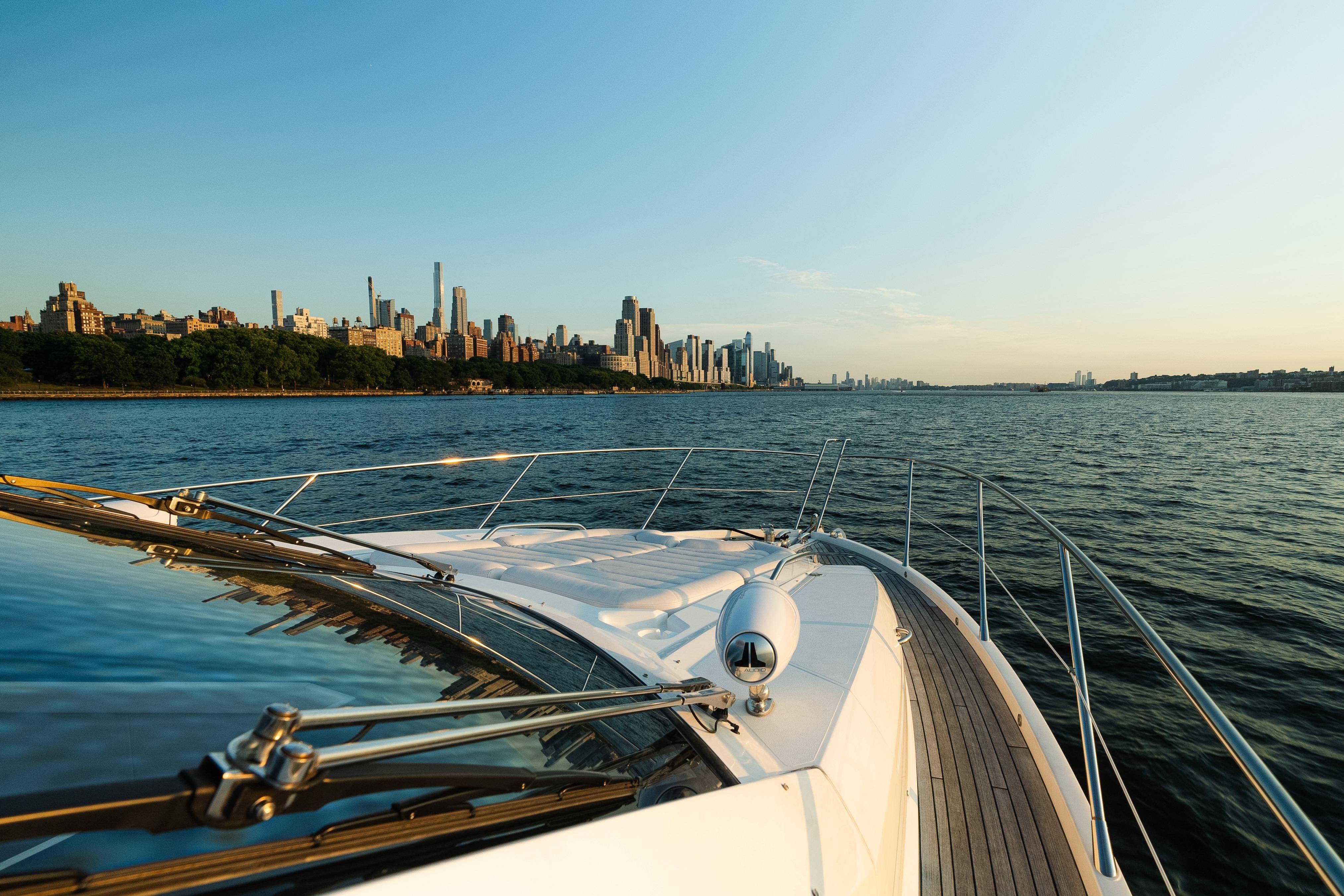 Sunseeker Manhattan 65 yacht cruising near city skyline at sunset, 2016 model.