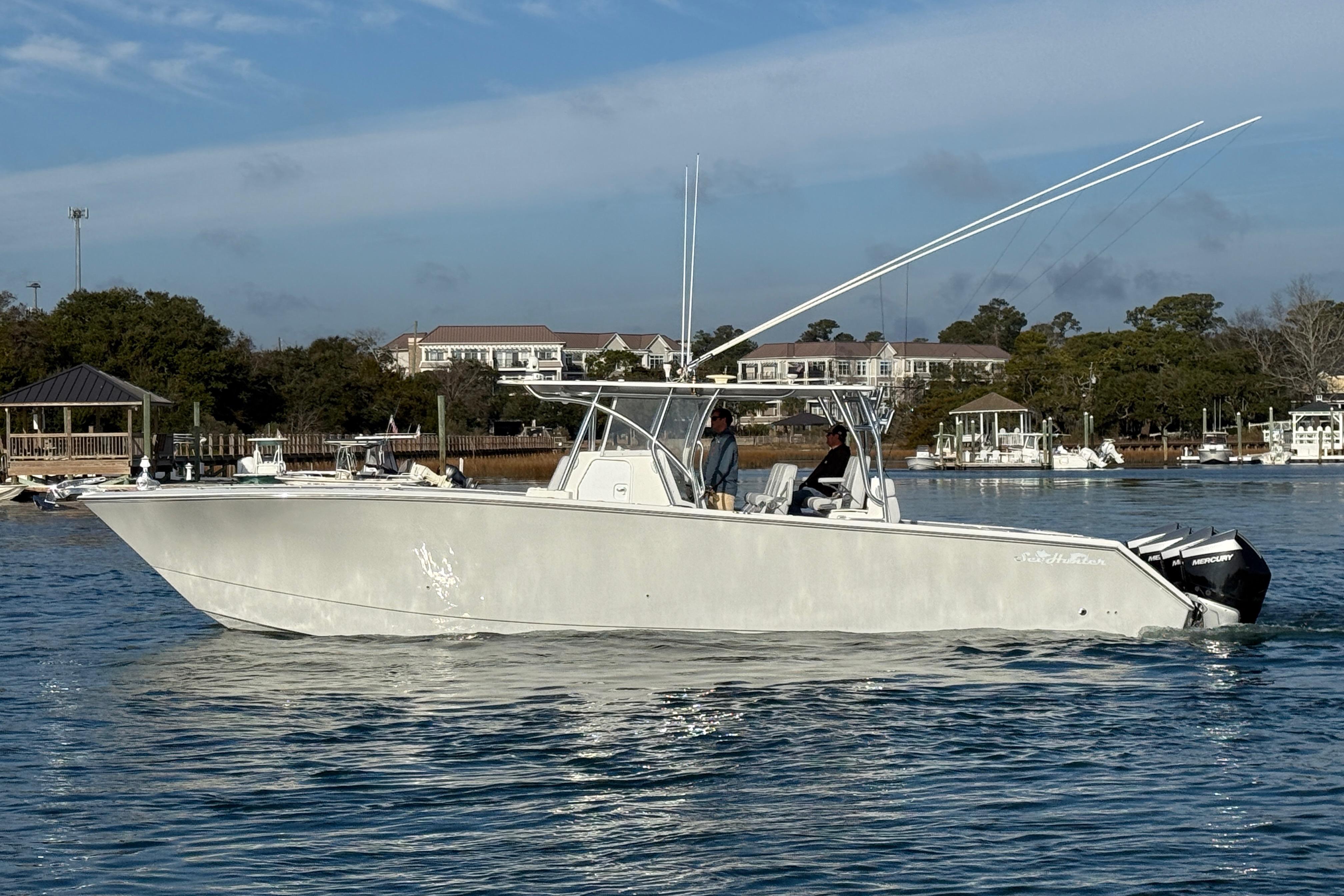 2021 SeaHunter 41 CTS boat cruising on calm water near a marina.
