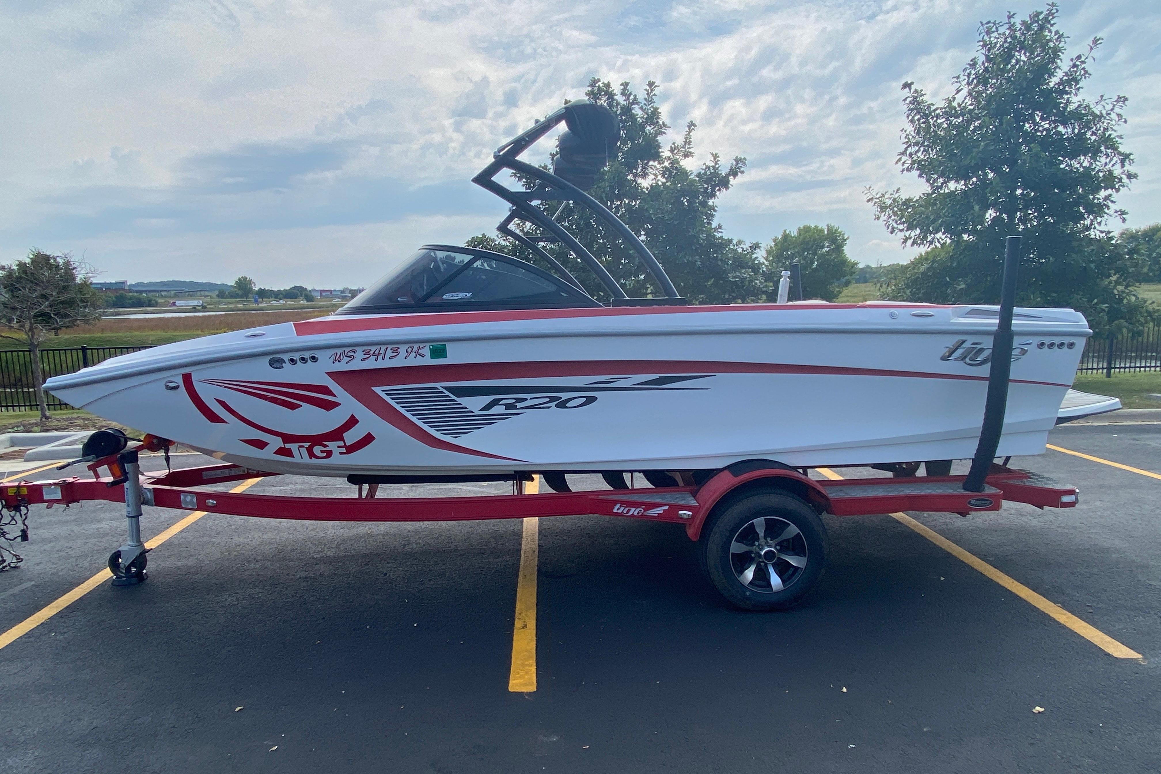 2014 Tigé R20 boat on a trailer in a parking lot, side view.