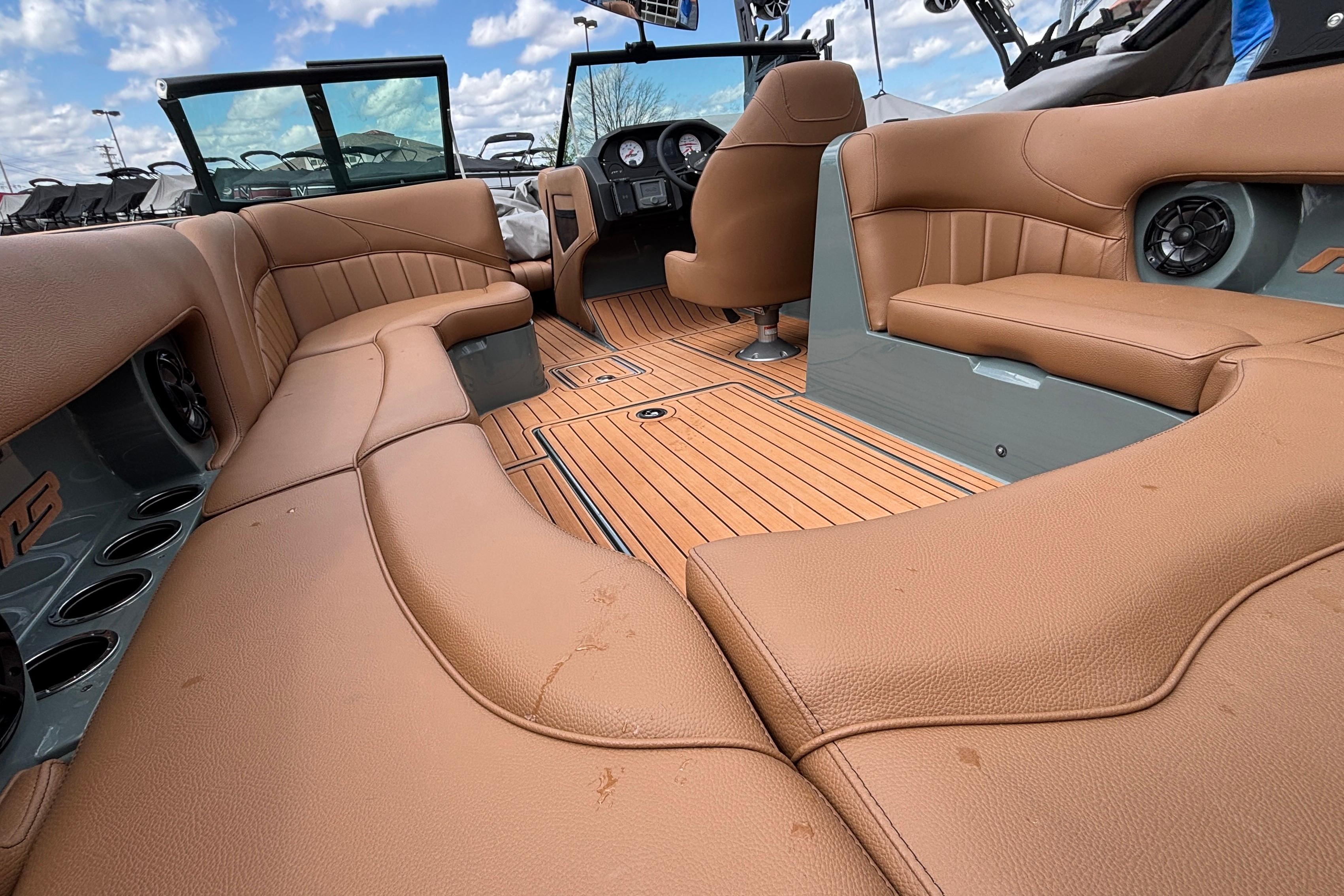 2026 MB B52 23 Classic boat interior with tan leather seating and wood flooring.