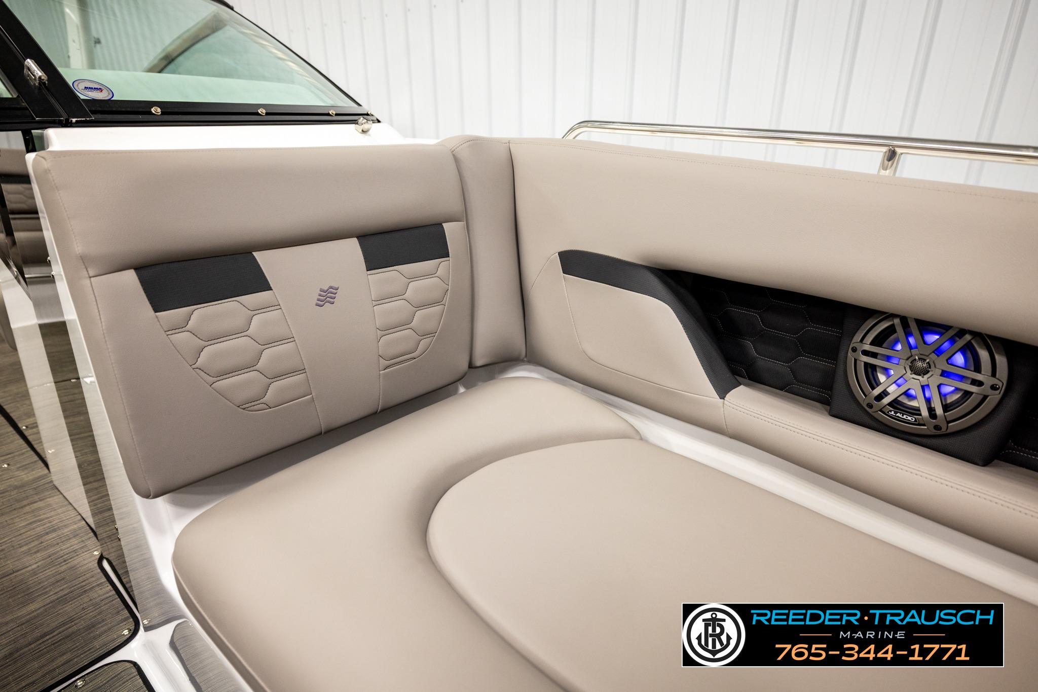 2024 FOURWINNS HD5 Surf boat interior with beige seating and built-in speaker.