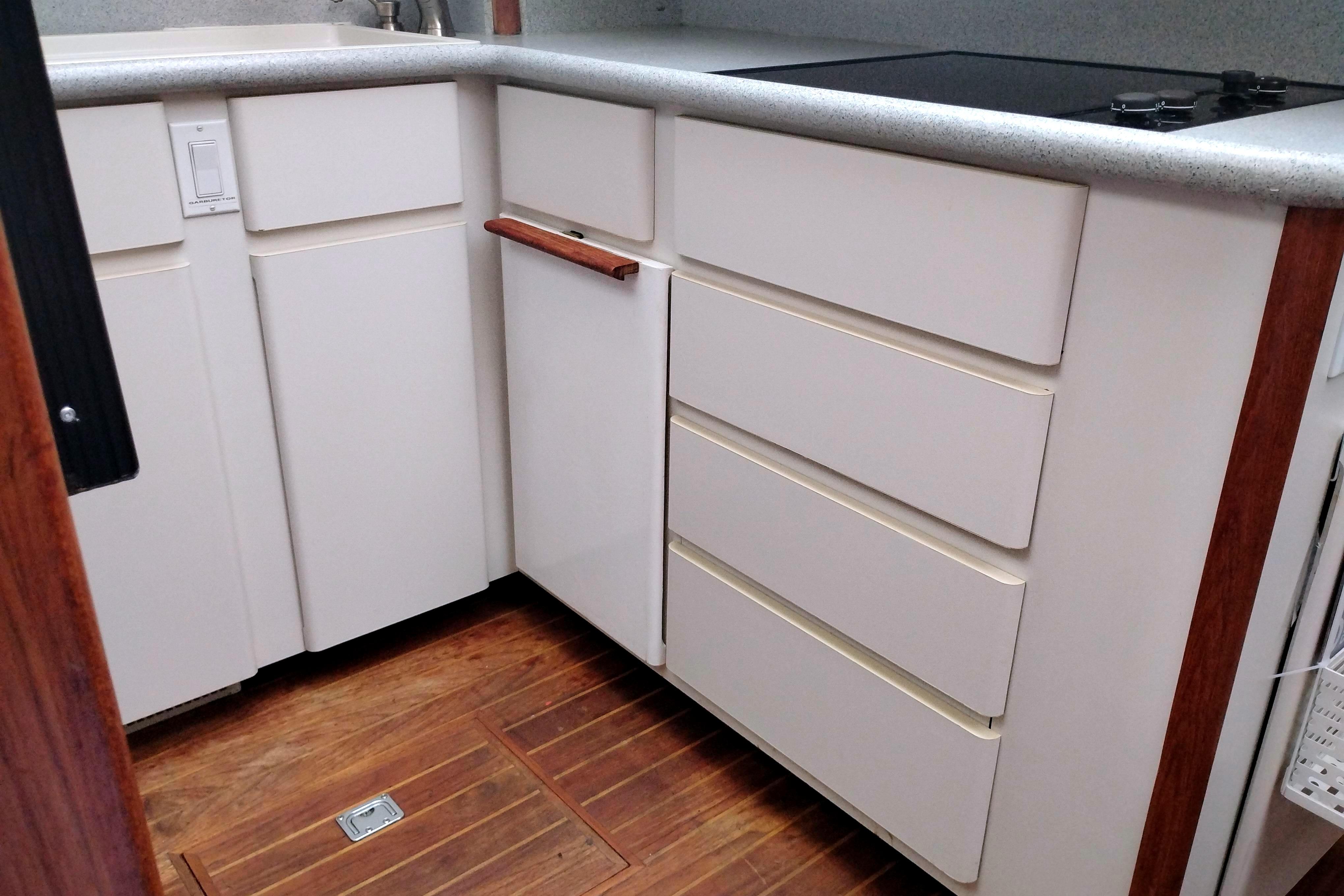 1991 Californian 52 Cockpit Motor Yacht kitchen with white cabinets and wooden flooring.