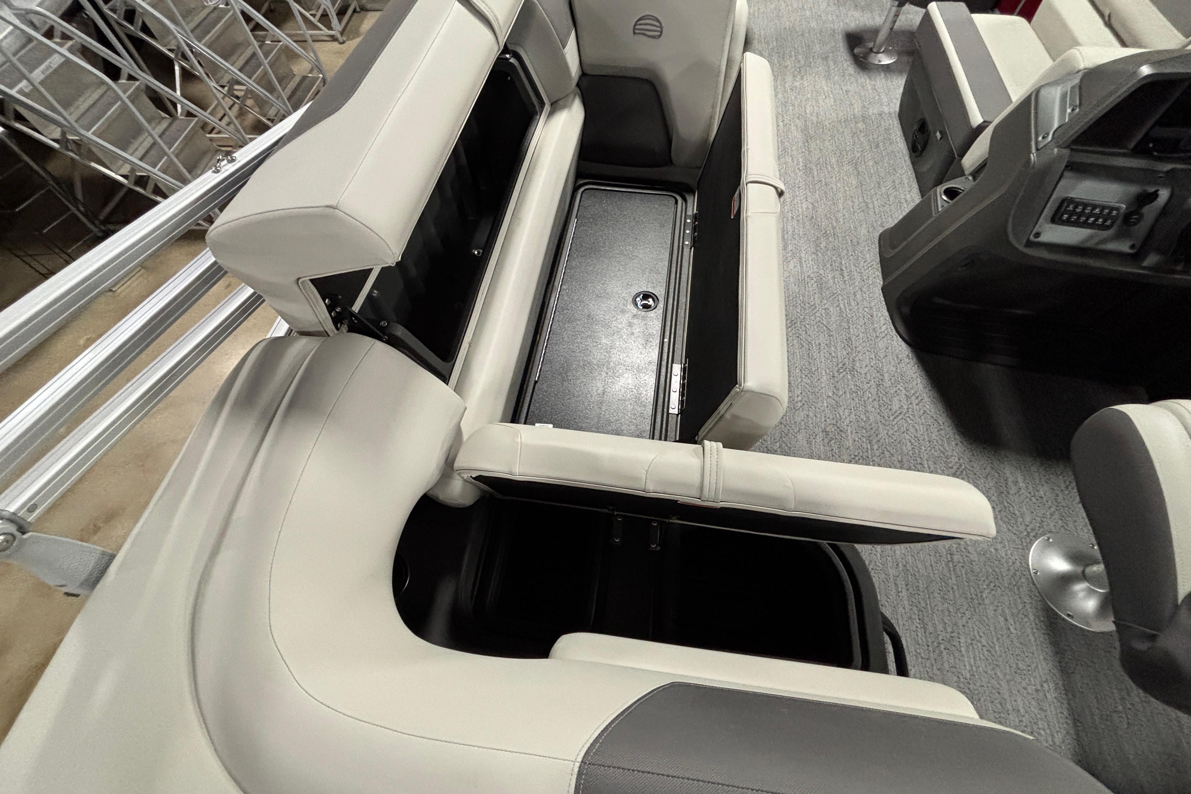 2026 Sun Tracker Fishin' Barge 22 DLX interior seating with storage compartments open.
