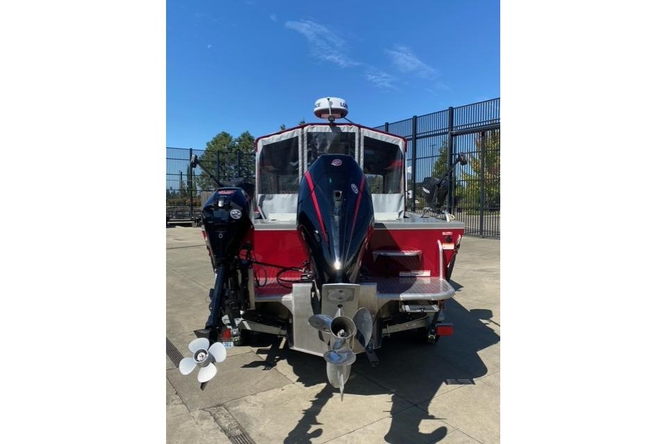 2023 Spartan 200 Astoria boat with dual outboard motors on a sunny day.