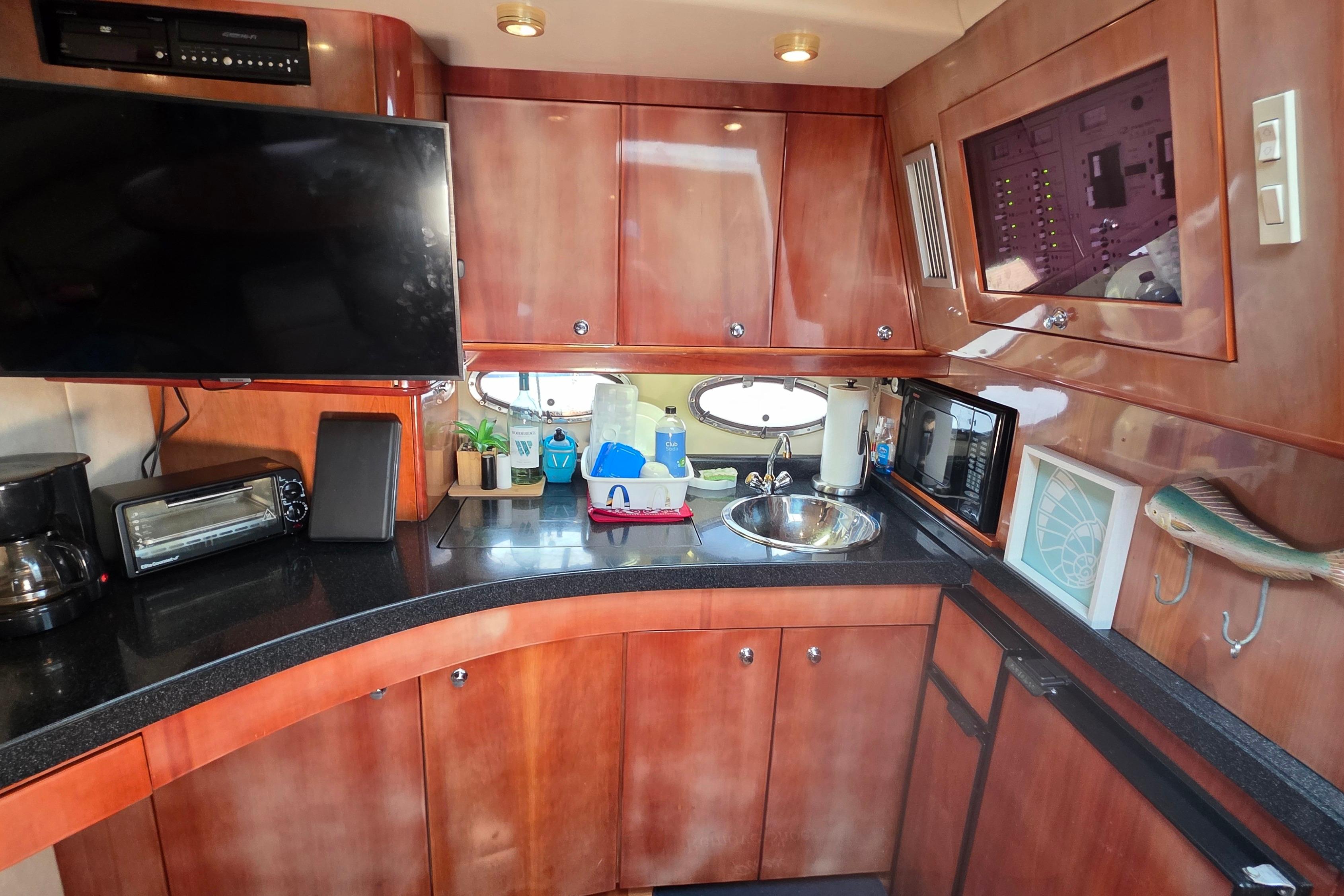 Luxurious 2002 Regal Commodore 4260 yacht kitchen with modern appliances and wood cabinetry.