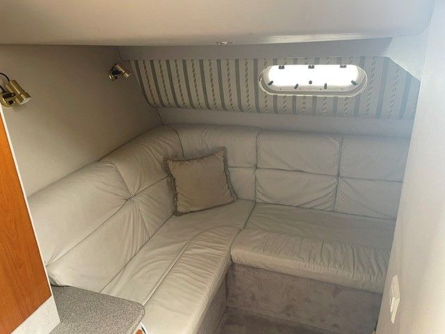 Interior of a 2002 Formula PC 37 with beige sofa and window.