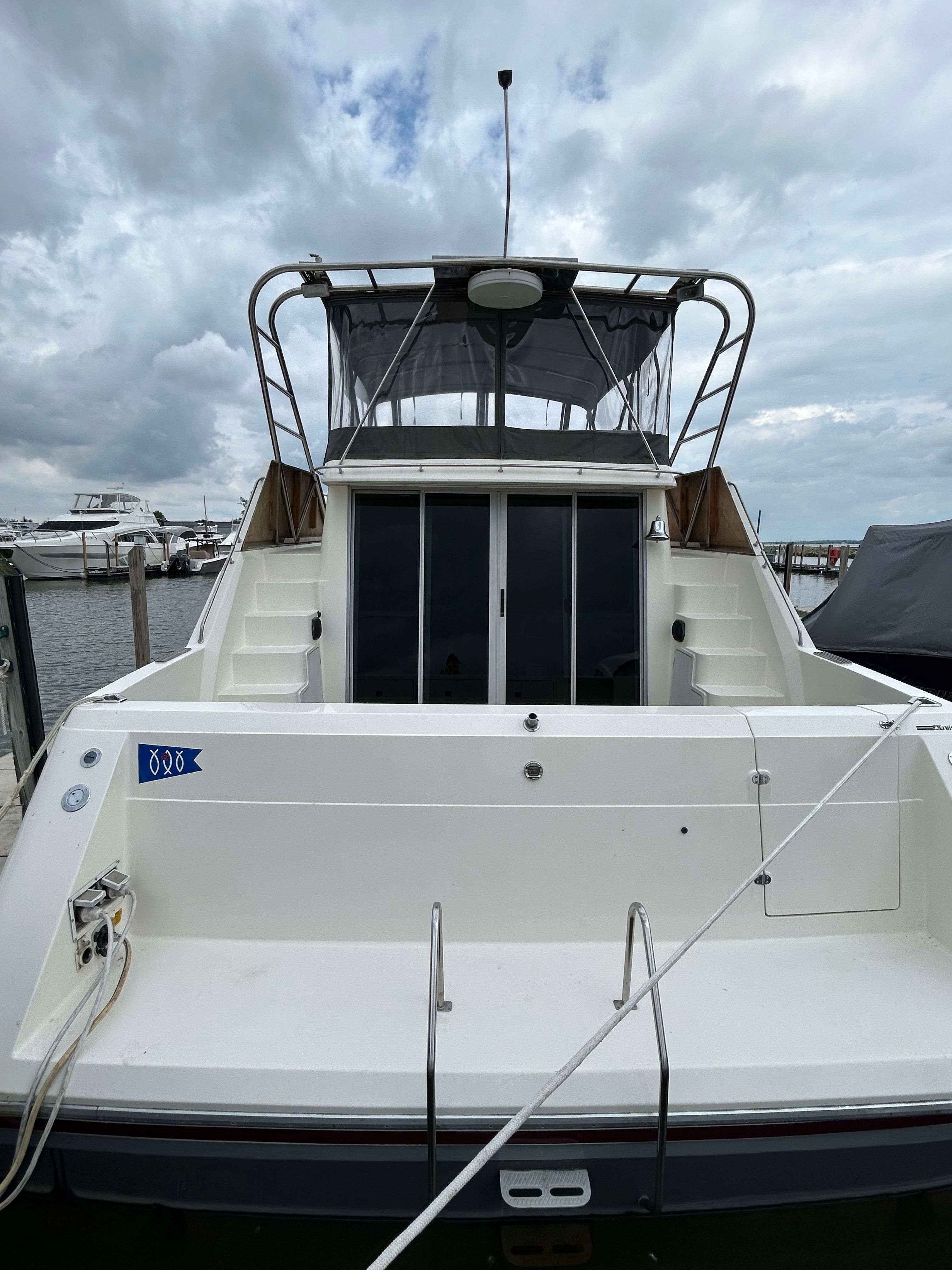 A 1988 Cruisers Yachts 4280 Express Bridge docked. It features a spacious aft deck.