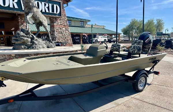 2024 Tracker Grizzly 1754 SC boat on trailer outside store.