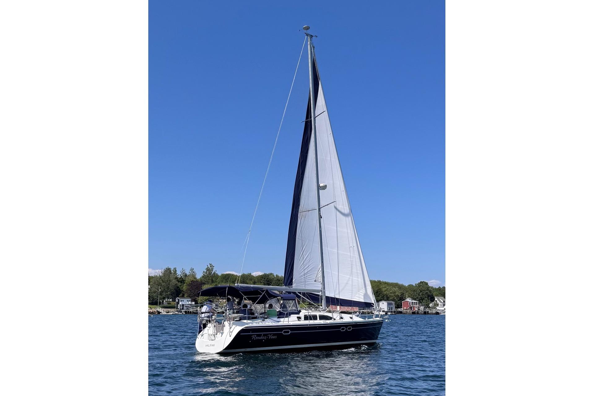 Sailboat Catalina 387, 2003 model, cruising on a sunny day with clear blue skies.