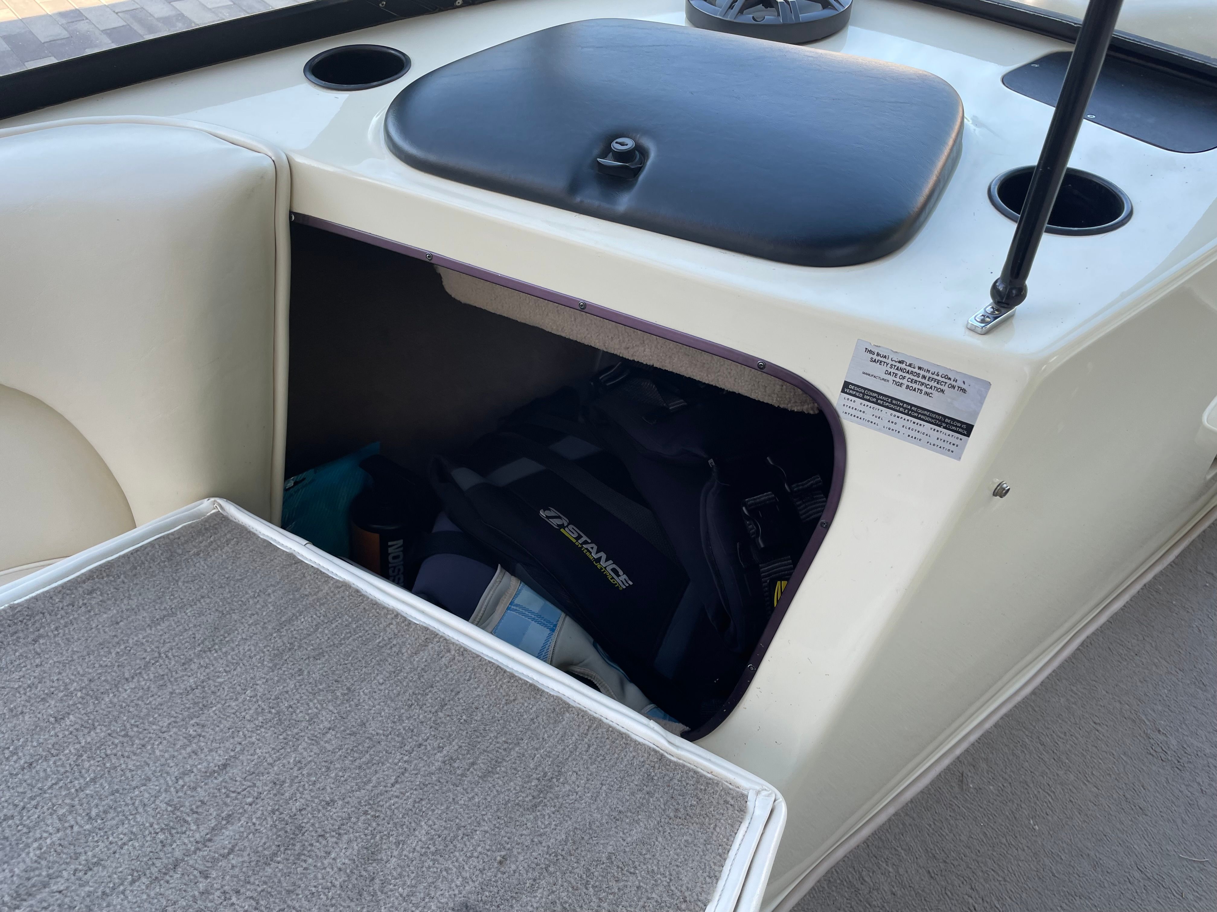 Interior of a 1998 Tigé Pre 2100 with storage compartment and seating area.