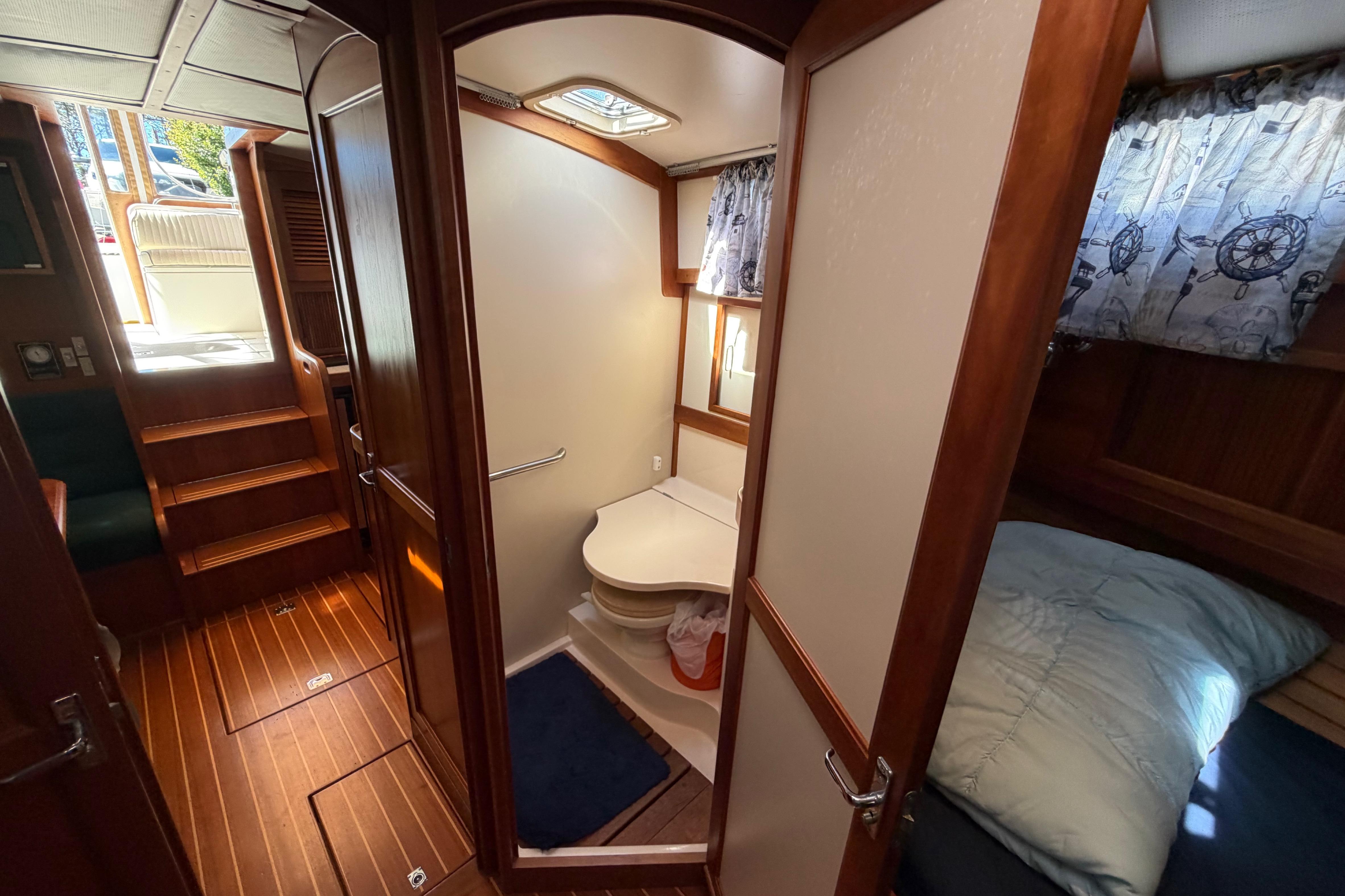 Interior of 2000 Sabreline 36 Express yacht, featuring cozy cabin and compact bathroom.