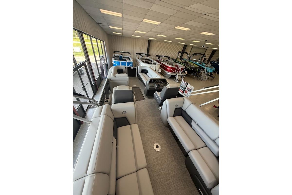 2026 Sun Tracker Party Barge 22 XP3 interior view in showroom with multiple boats.