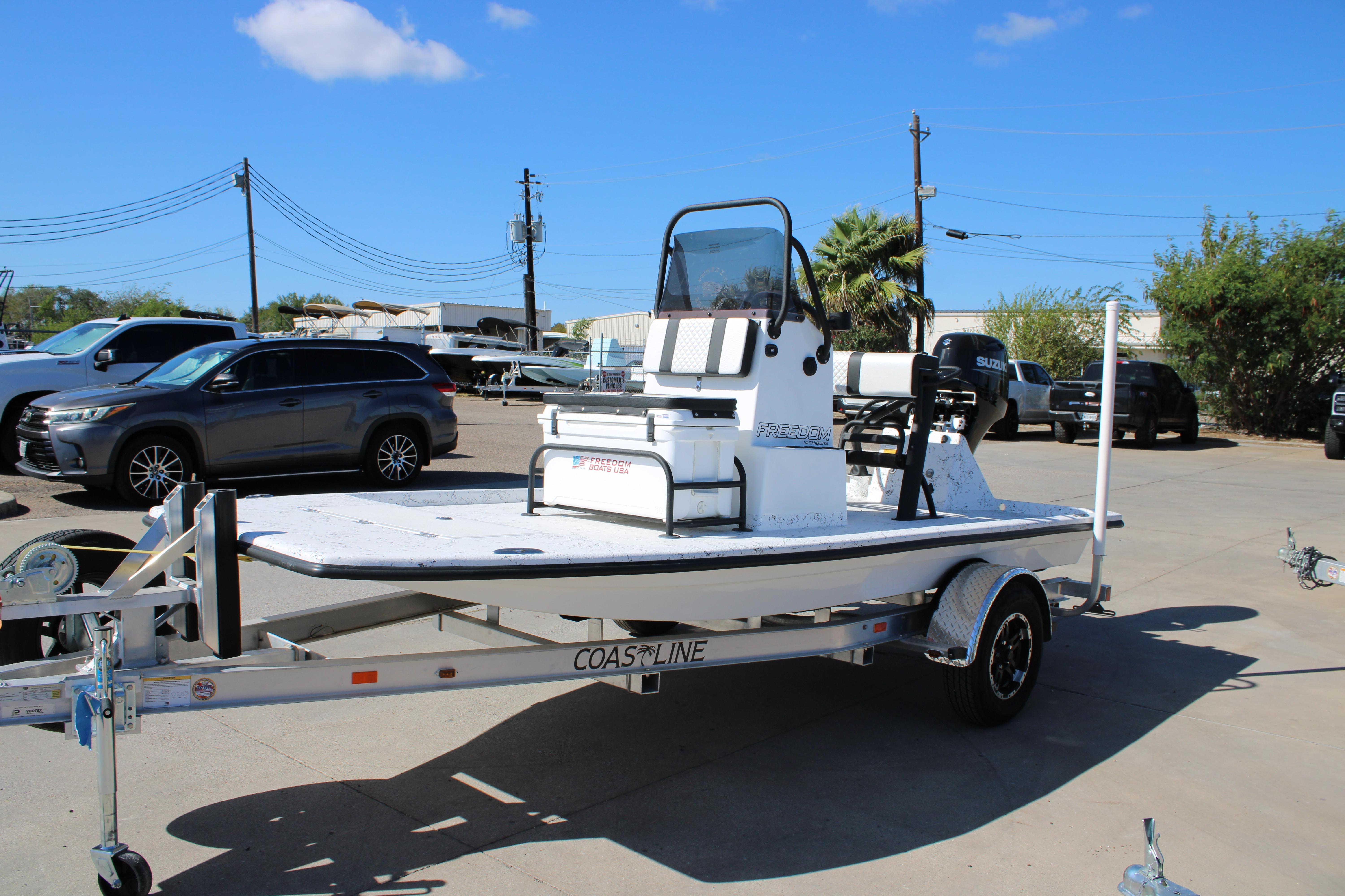 2026 Freedom Boats Chiquita on trailer, parked outdoors under clear blue sky.
