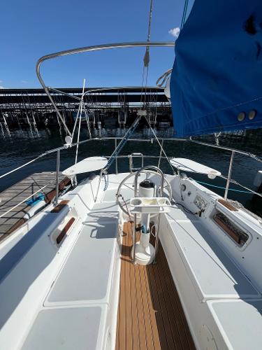 1980 Catalina 30 sailboat cockpit with white seating and wooden flooring, docked at marina.