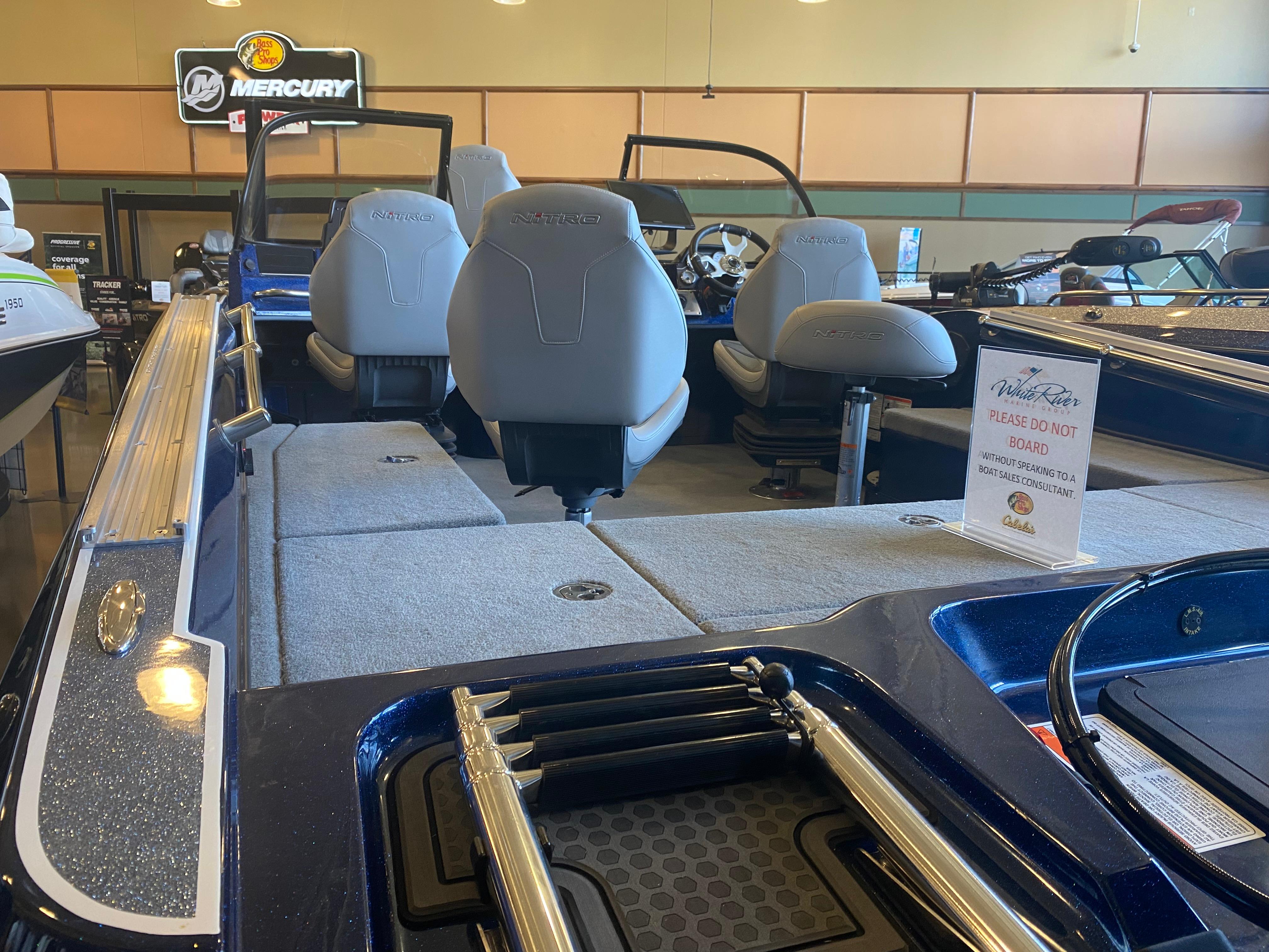 2025 Nitro ZV20 Pro boat interior with seating and a caution sign in a showroom.