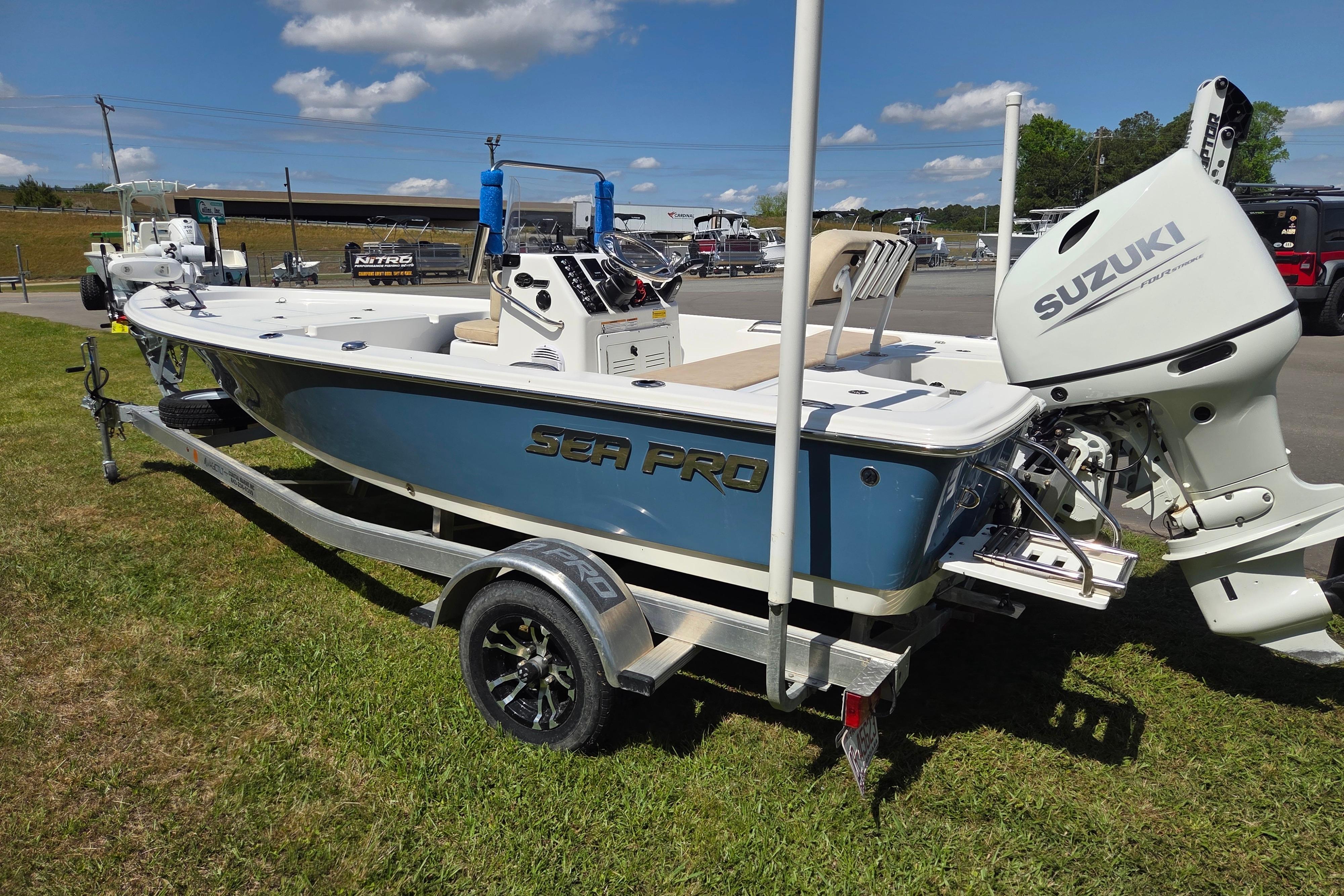 2024 Sea Pro 172 Bay boat with Suzuki engine on trailer, parked outdoors.