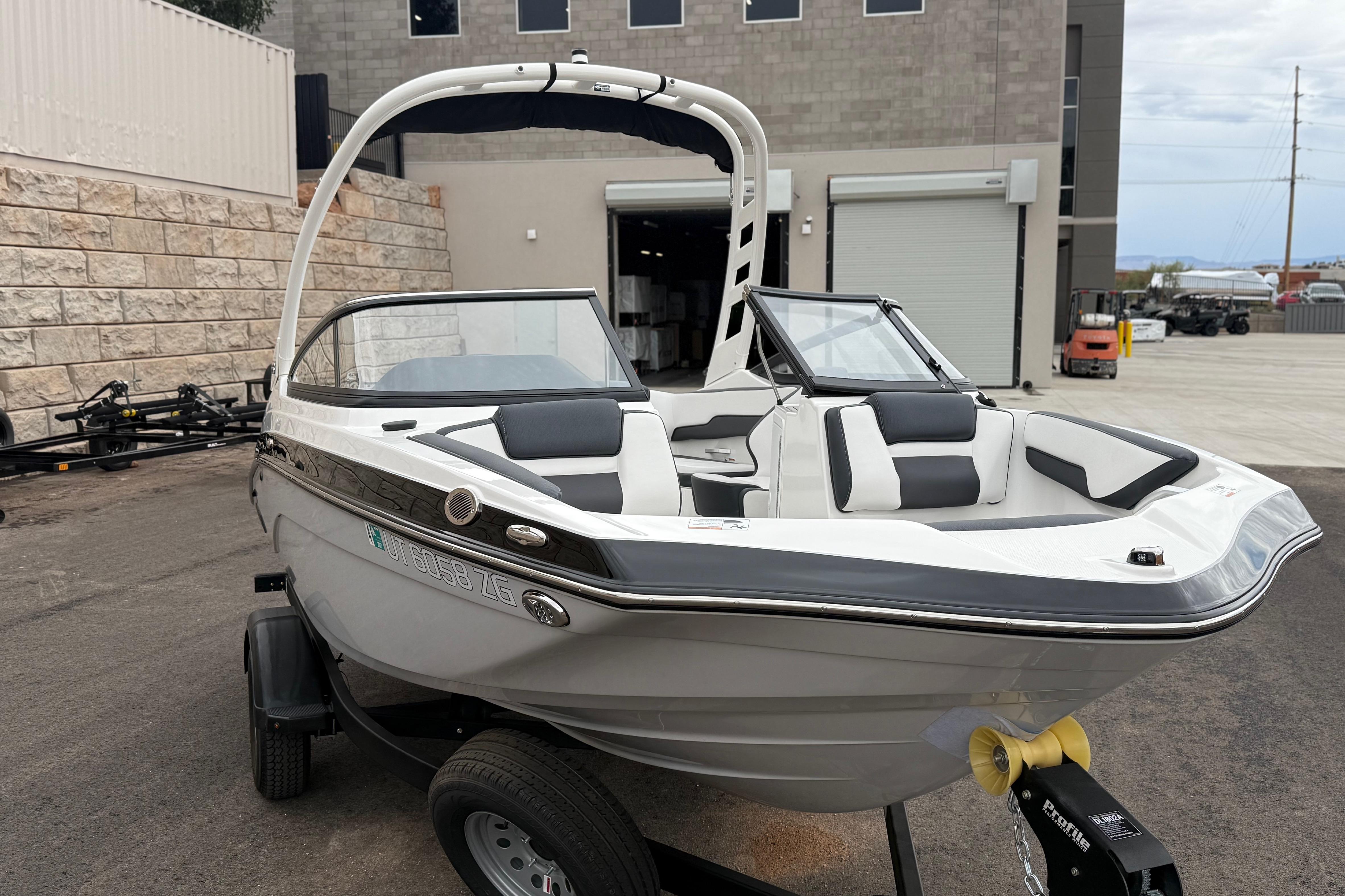 2025 Yamaha Boats 195S on trailer, sleek design, parked outdoors near industrial building.