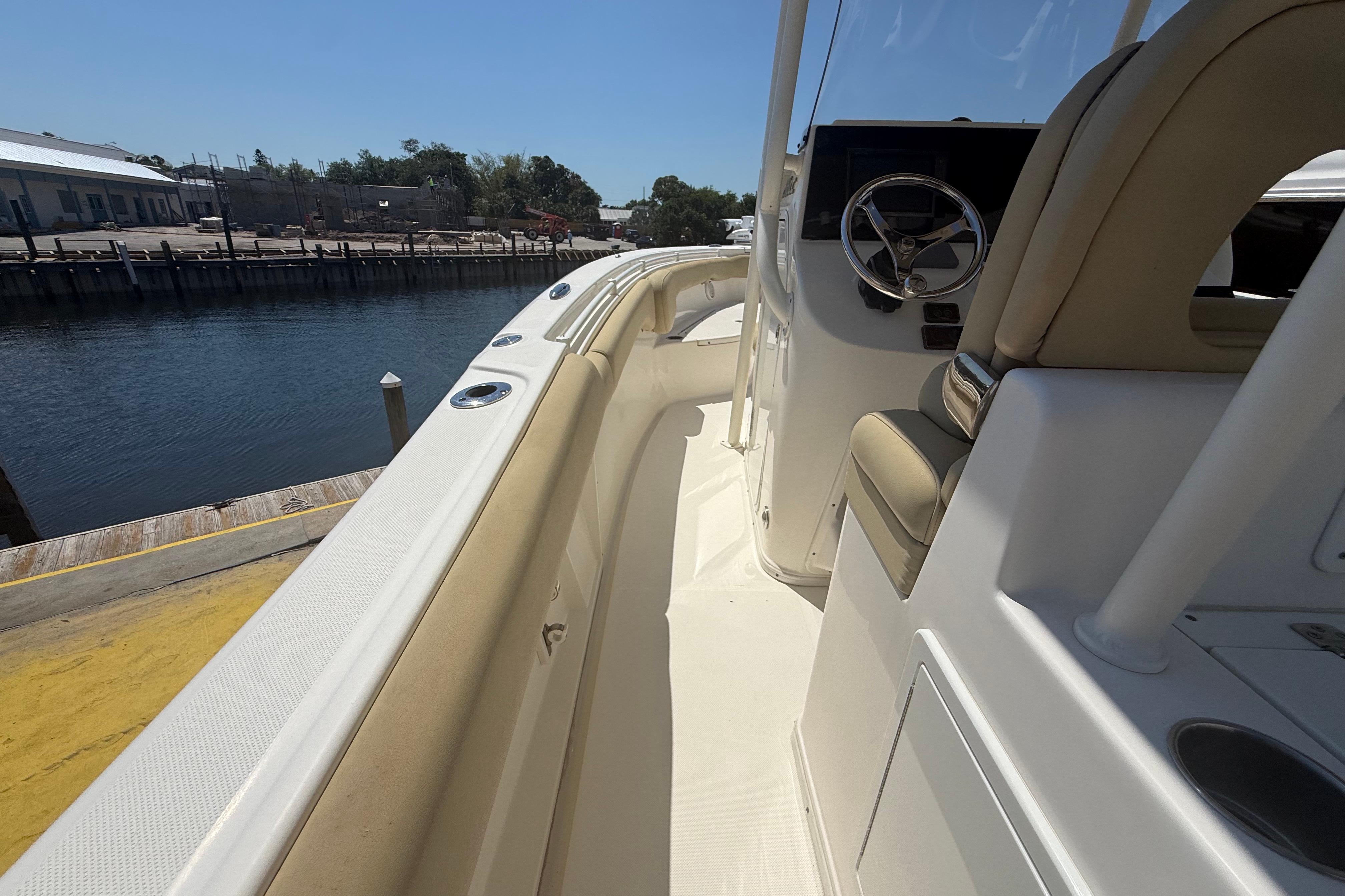 2019 Key West Billistic 281 Center Console boat docked by a calm waterfront.