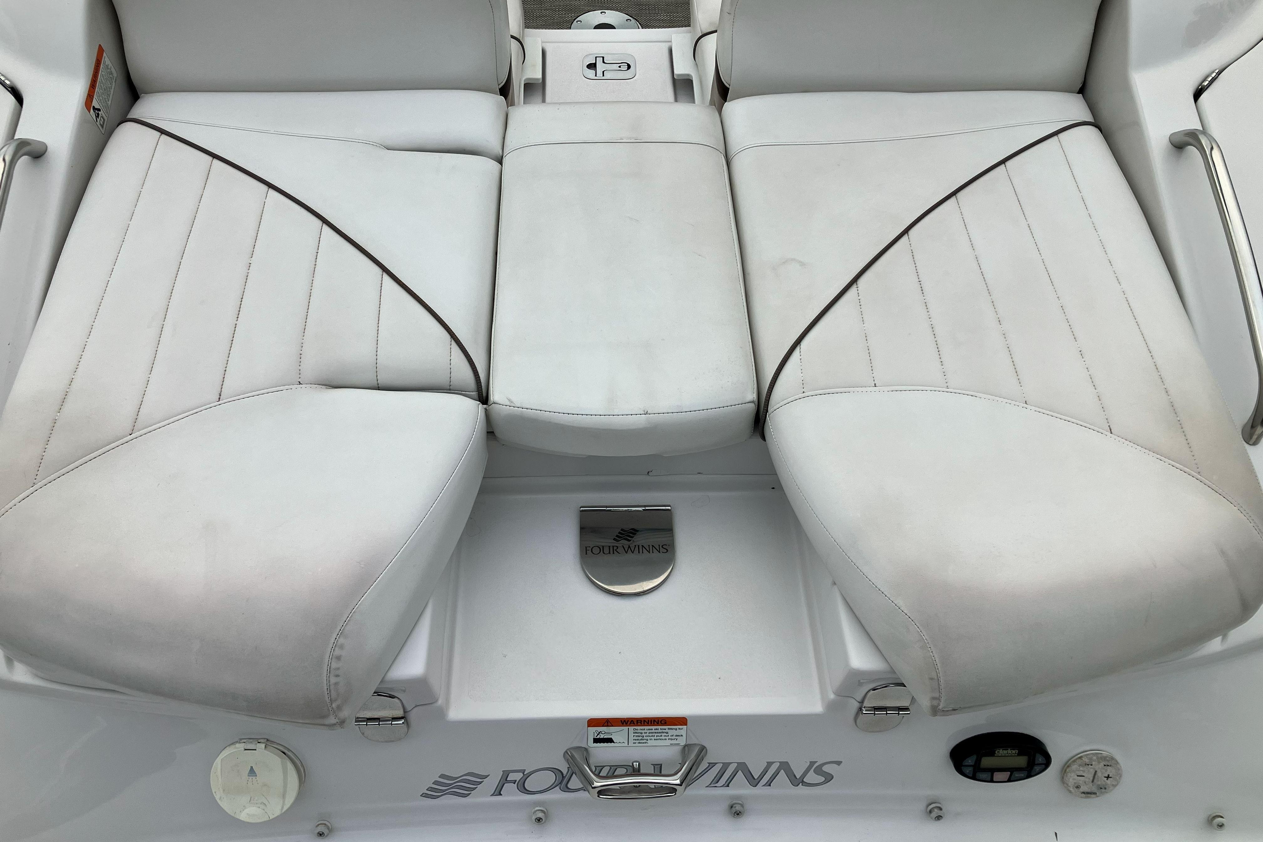 2006 Four Winns 240 Horizon boat seating area with white upholstery and logo.