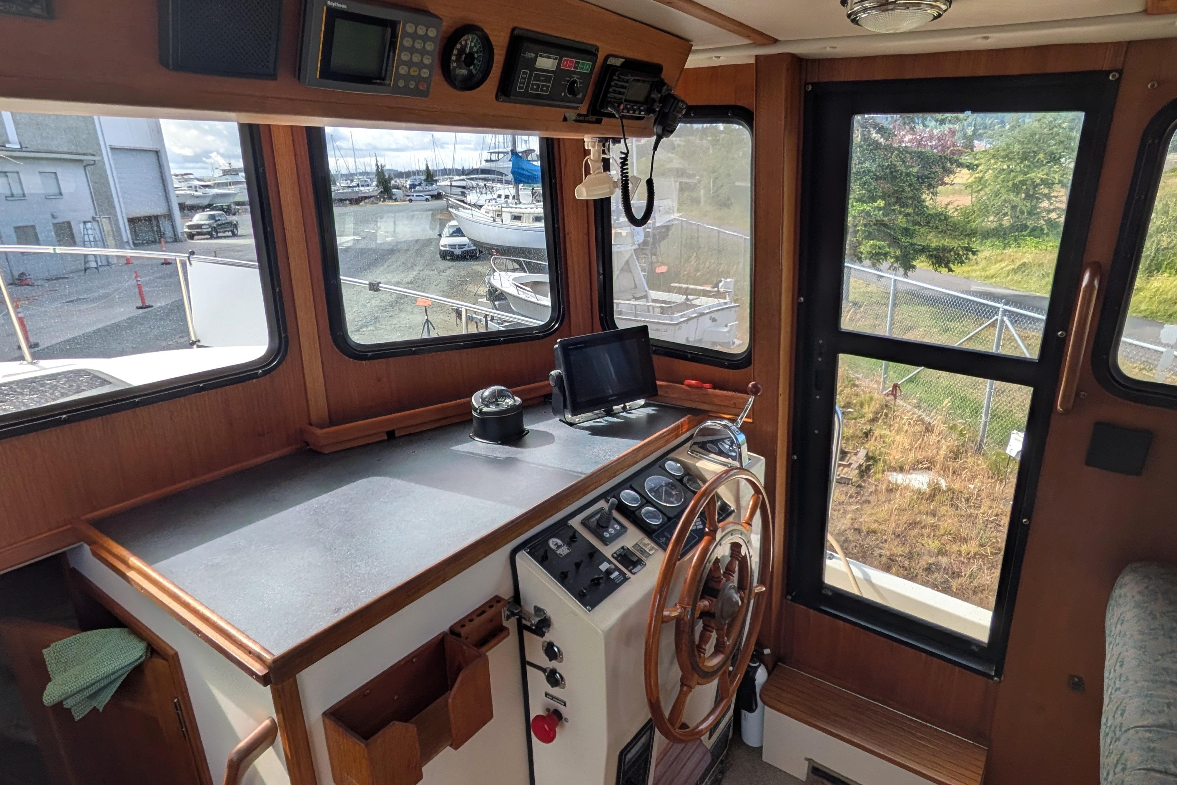 1998 Nordic Tug 32 helm with wooden steering wheel and navigation equipment.