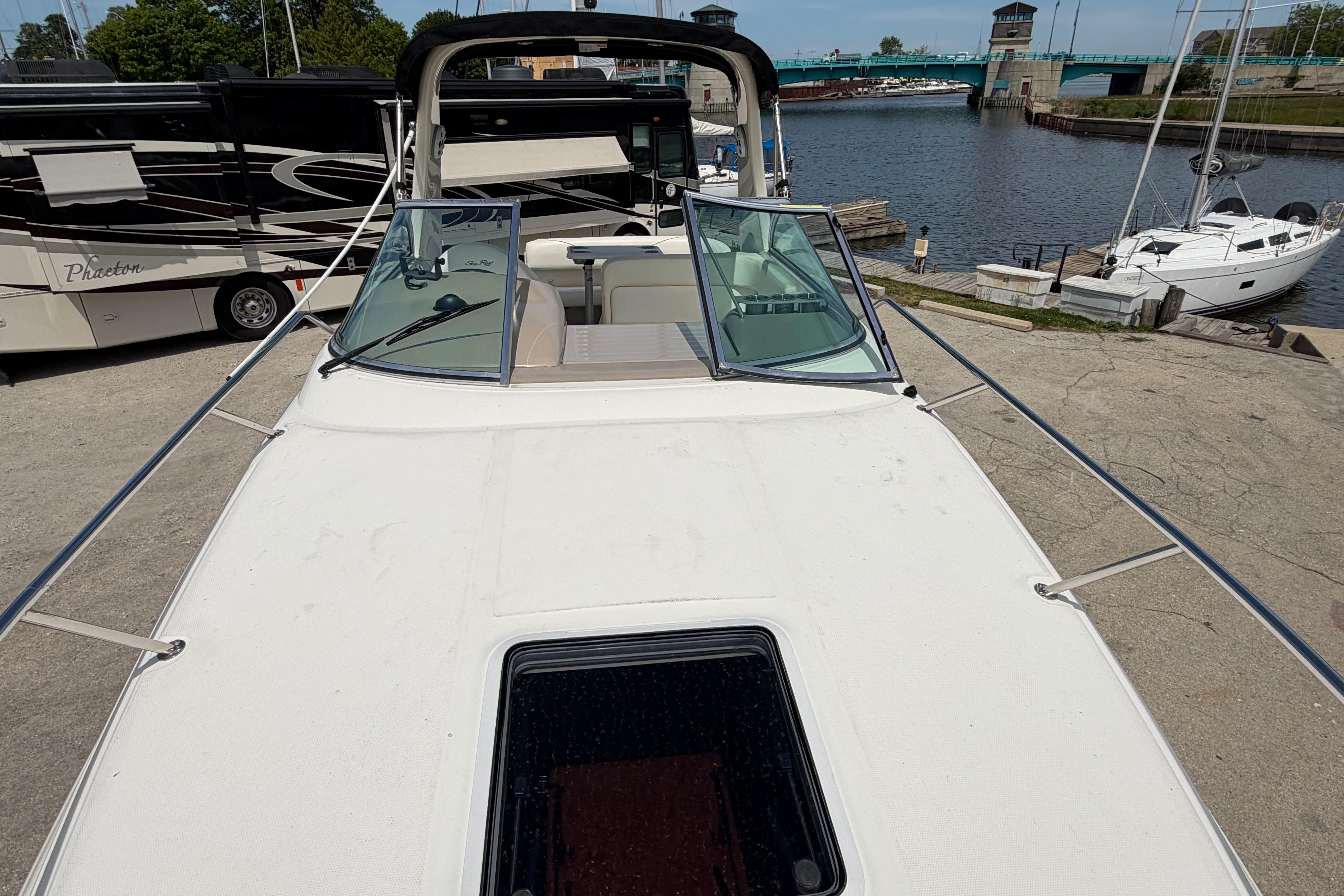 2004 Sea Ray Sundancer 260 boat docked near a marina with clear skies.