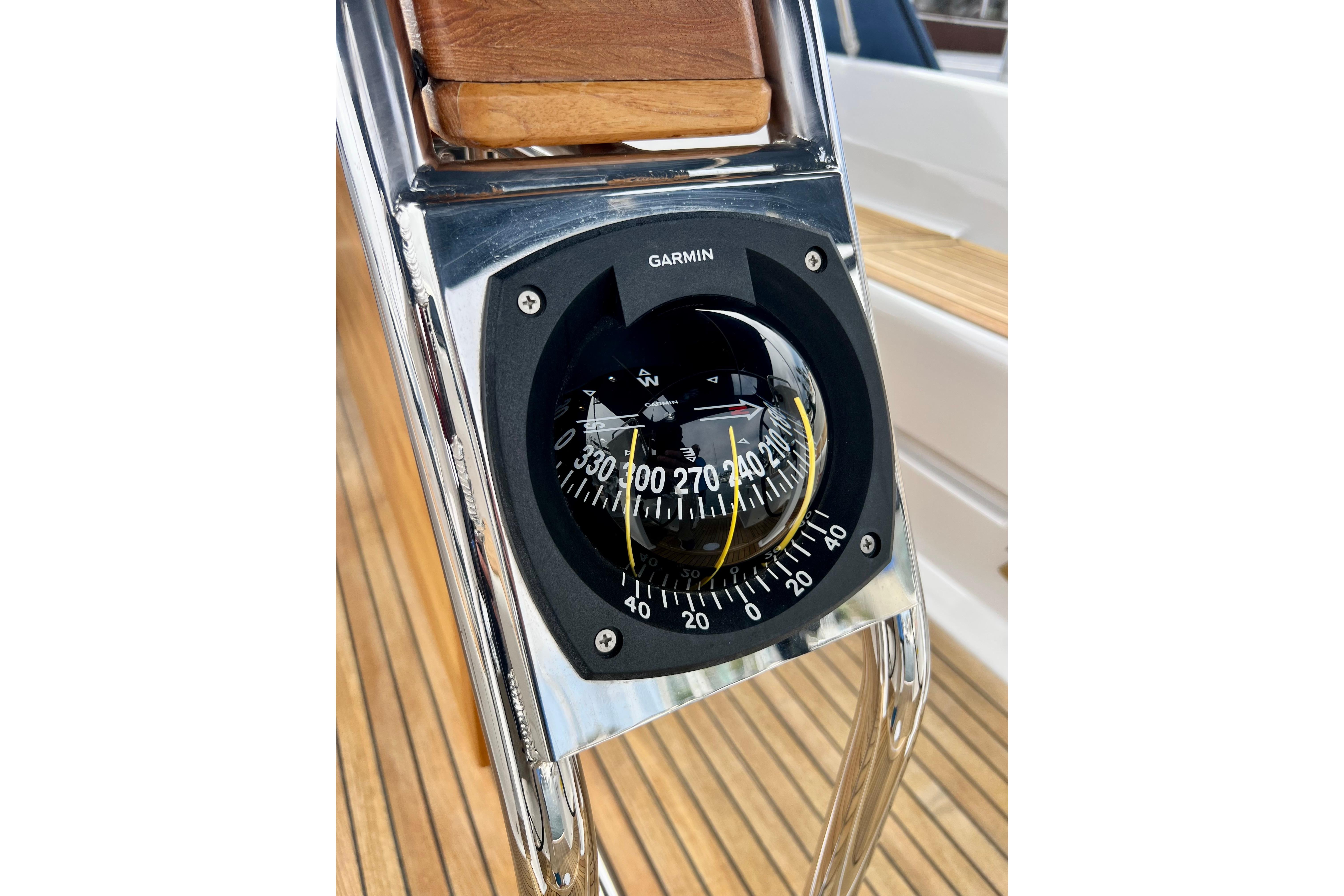 Compass on 2016 Hanse 455 yacht, featuring Garmin navigation, with teak deck background.